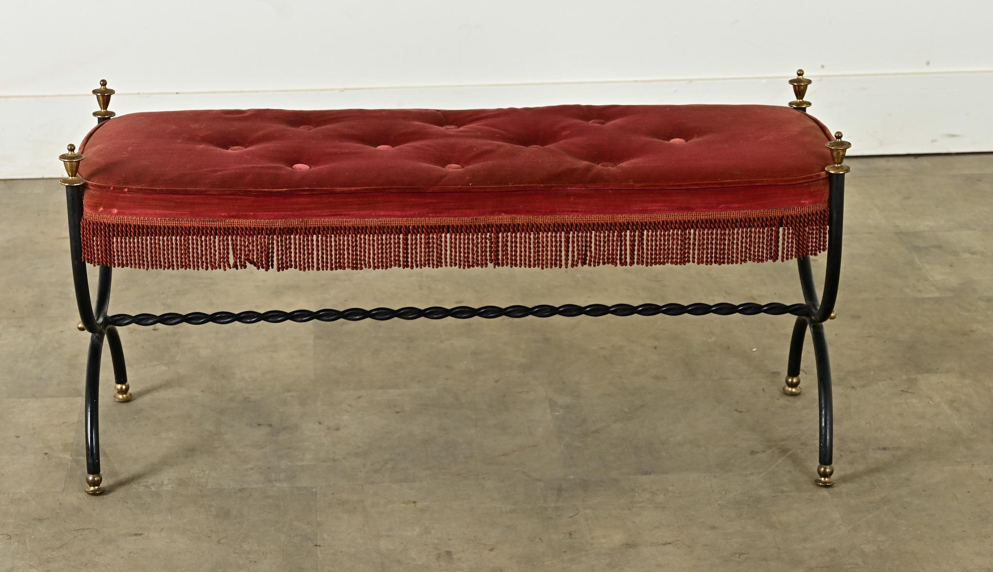 Gorgeous velvet and iron bench in the style of Maison Jansen, the pioneering French design firm of the early 20th century. The tufted burgundy velvet cushion is soft and comfortable, the shape is curved at the corners to bypass the iron frame which