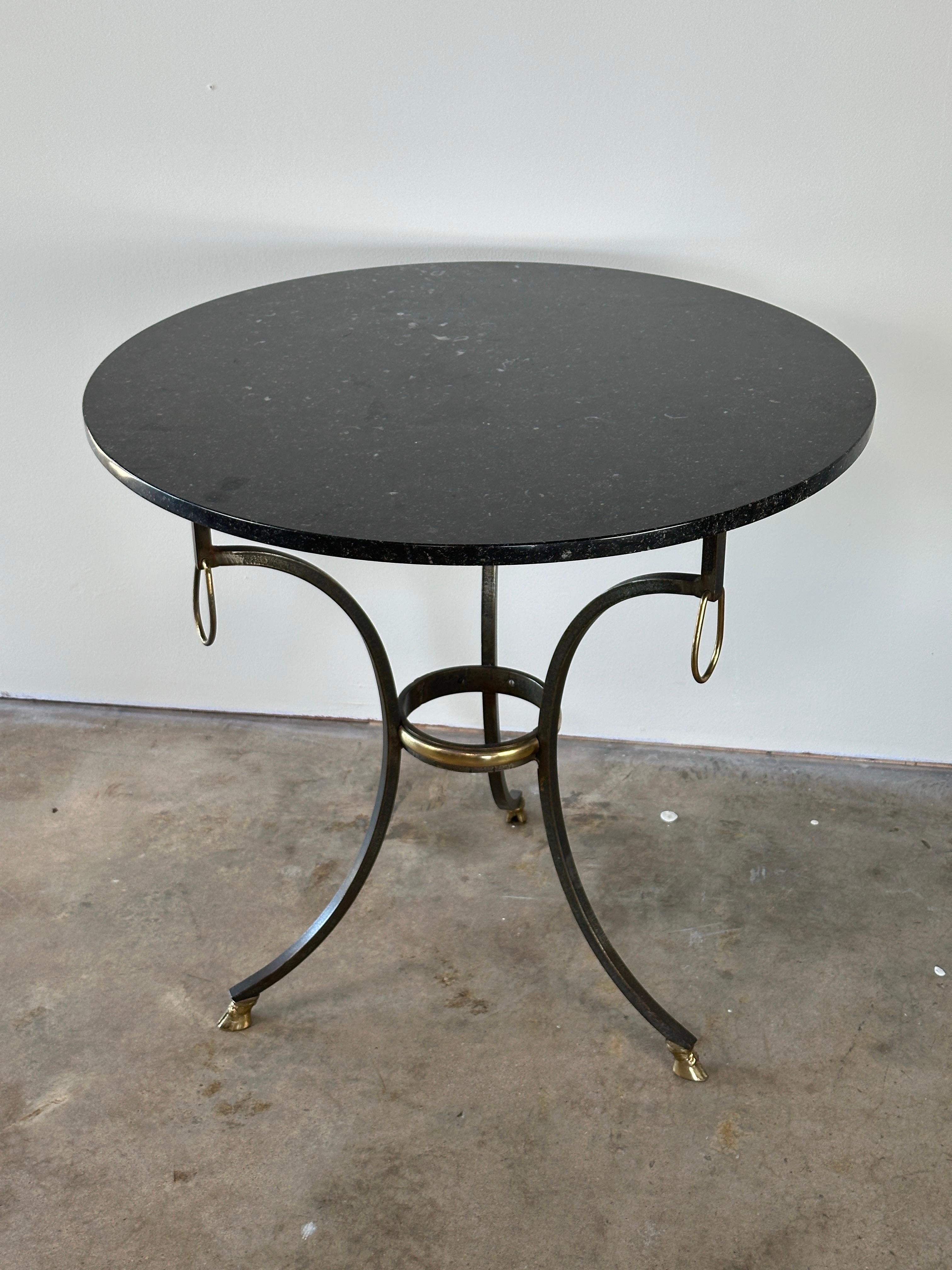 Neoclassical style iron and brass gueridon with stone top and hoof feet, attributed to the renowned designer and antiques purveyor Yale R Burge. Early to mid 20th century.

Condition is very good, iron base is sturdy, brass details show natural