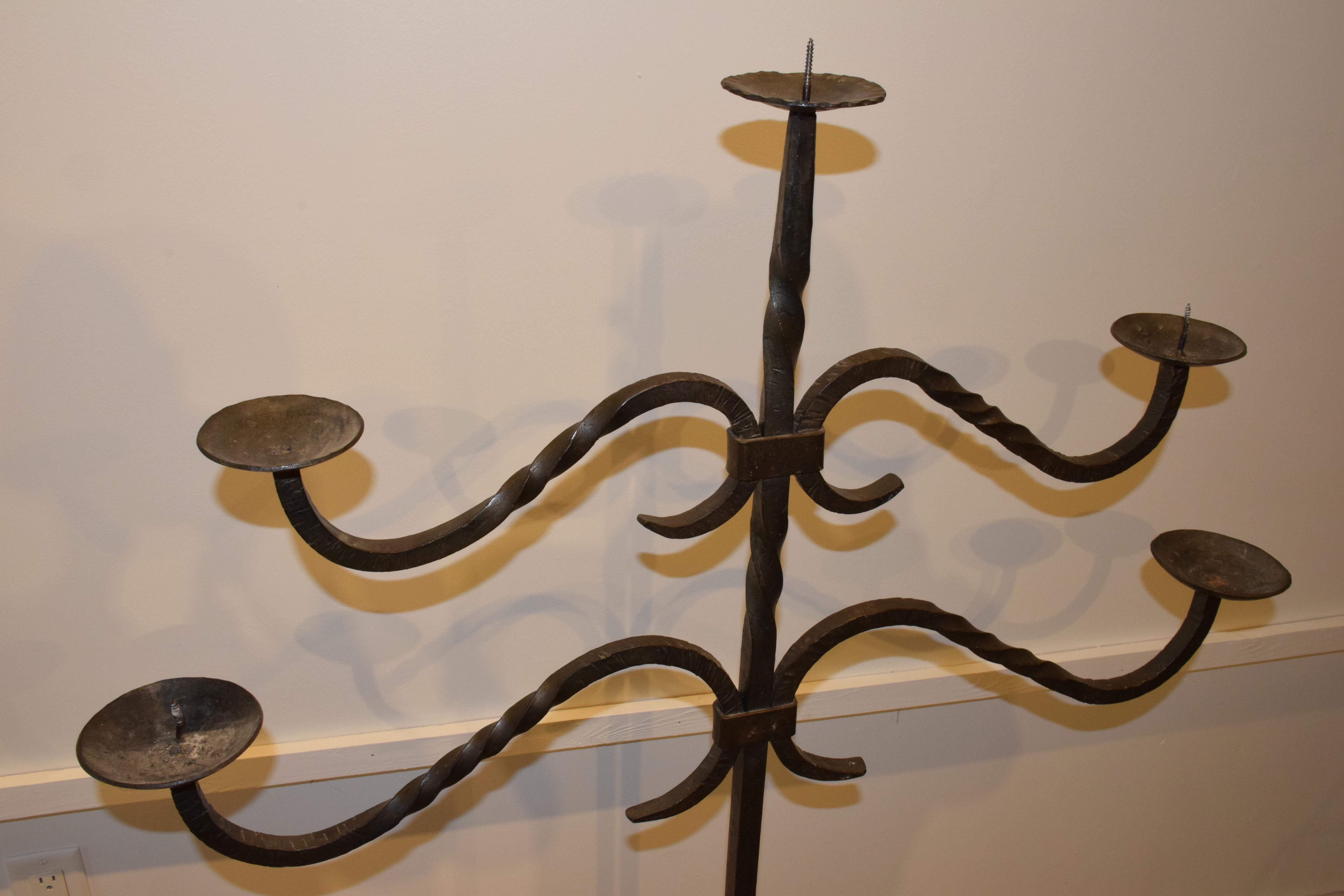 Found in the South of France, this hand forged iron floor candelabra with five arms depicts unique craftsmanship. Although two of the spikes are missing, this candelabra will hold up to a 2.5 inch pillar candle on each arm. This would make a great