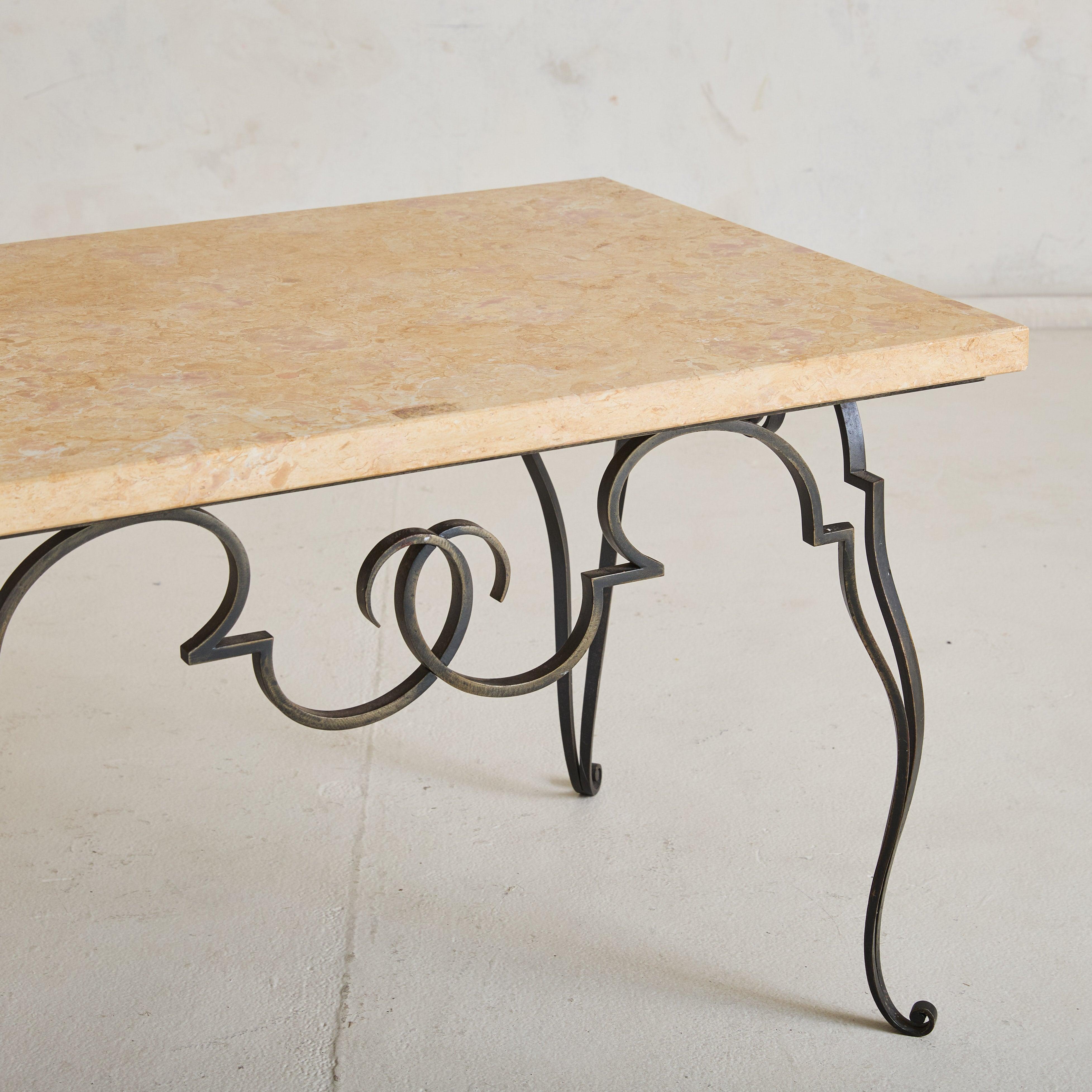 Esta mesa de centro francesa de los años 50 presenta una ornamentada base de hierro forjado acentuada con elegantes detalles curvilíneos. Sus intrincadas volutas y patas escultóricas crean una sensación de ligereza que complementa a la perfección la