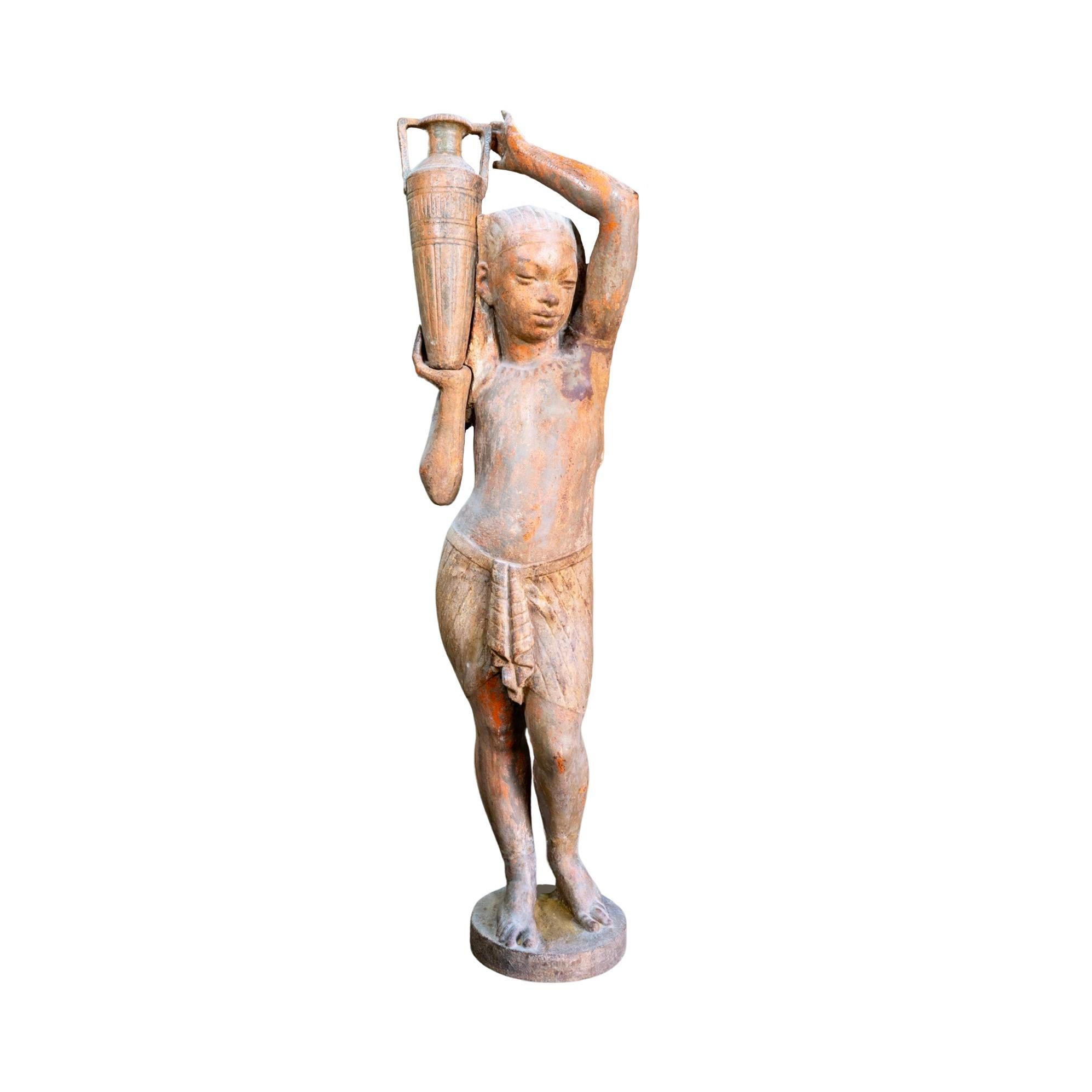 Expertly crafted in the 1890s, this French Iron Egyptian Water Bearer Sculpture showcases exquisite solid cast iron construction. With a beautiful patina wear that adds character, this sculpture is a nod to ancient Egyptian art. Elevate your home