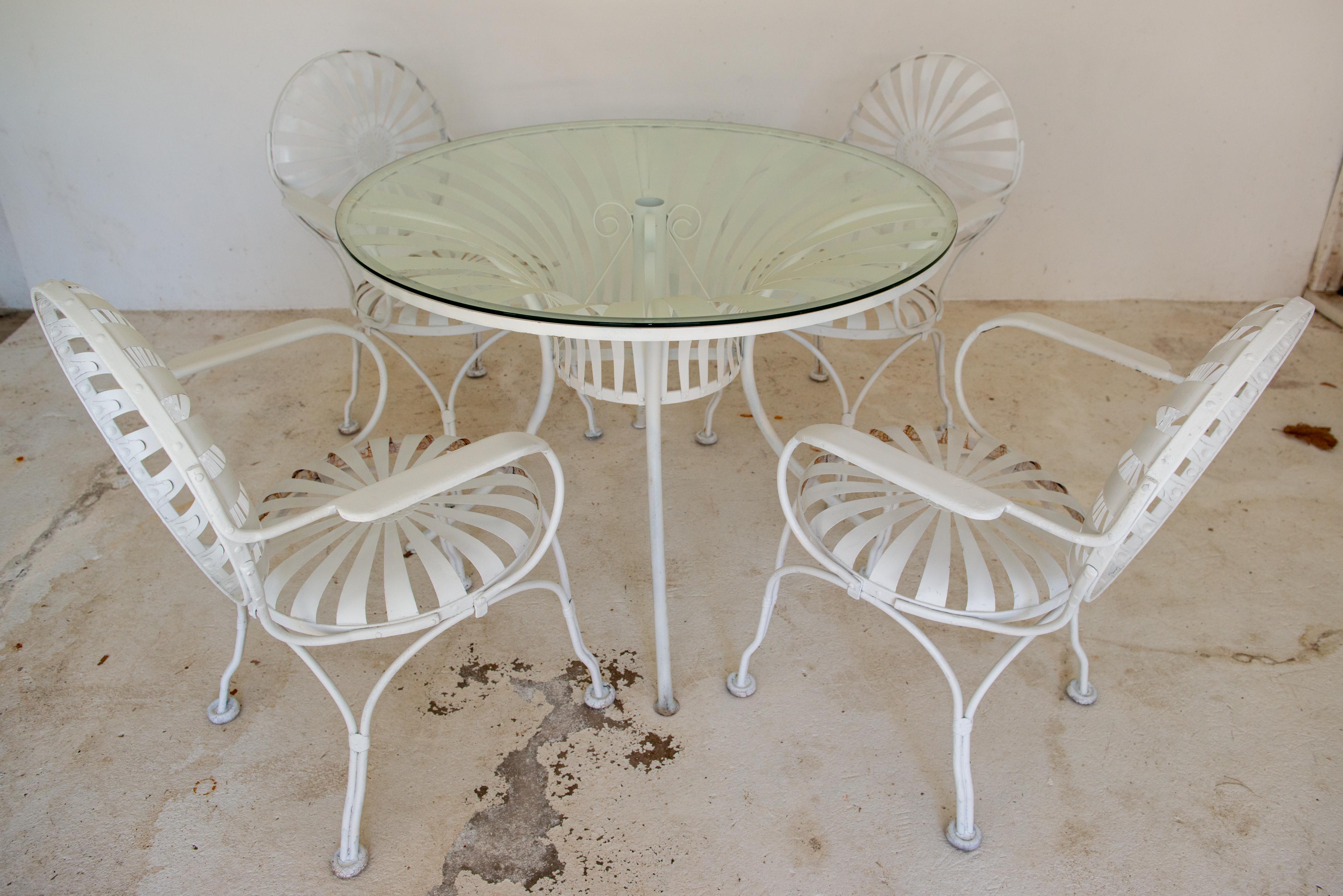 Der französische Designer Francois Carre entwarf in den 1930er Jahren diese exquisiten Gartenstühle mit Federleisten aus Stahl und den dazu passenden Esstisch mit Glasplatte aus runden Federleisten. Sie sind auch fast 100 Jahre später noch attraktiv