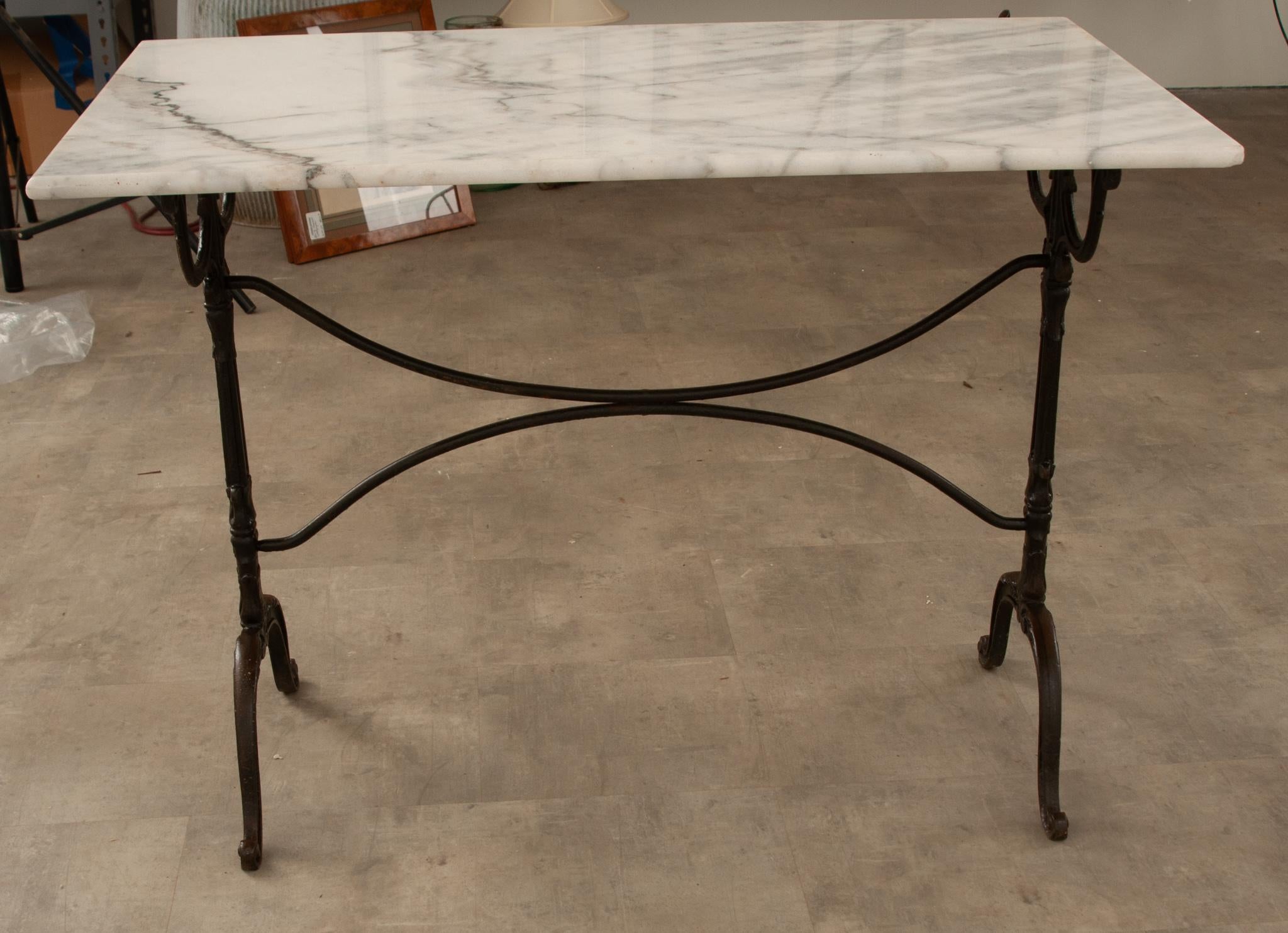 A delightful French marble-top bistro table with a classically styled black painted iron base. The marble top has beautiful charcoal veining and inclusions throughout. The base has X-form supports and the scroll-form feet. Great for an outdoor patio