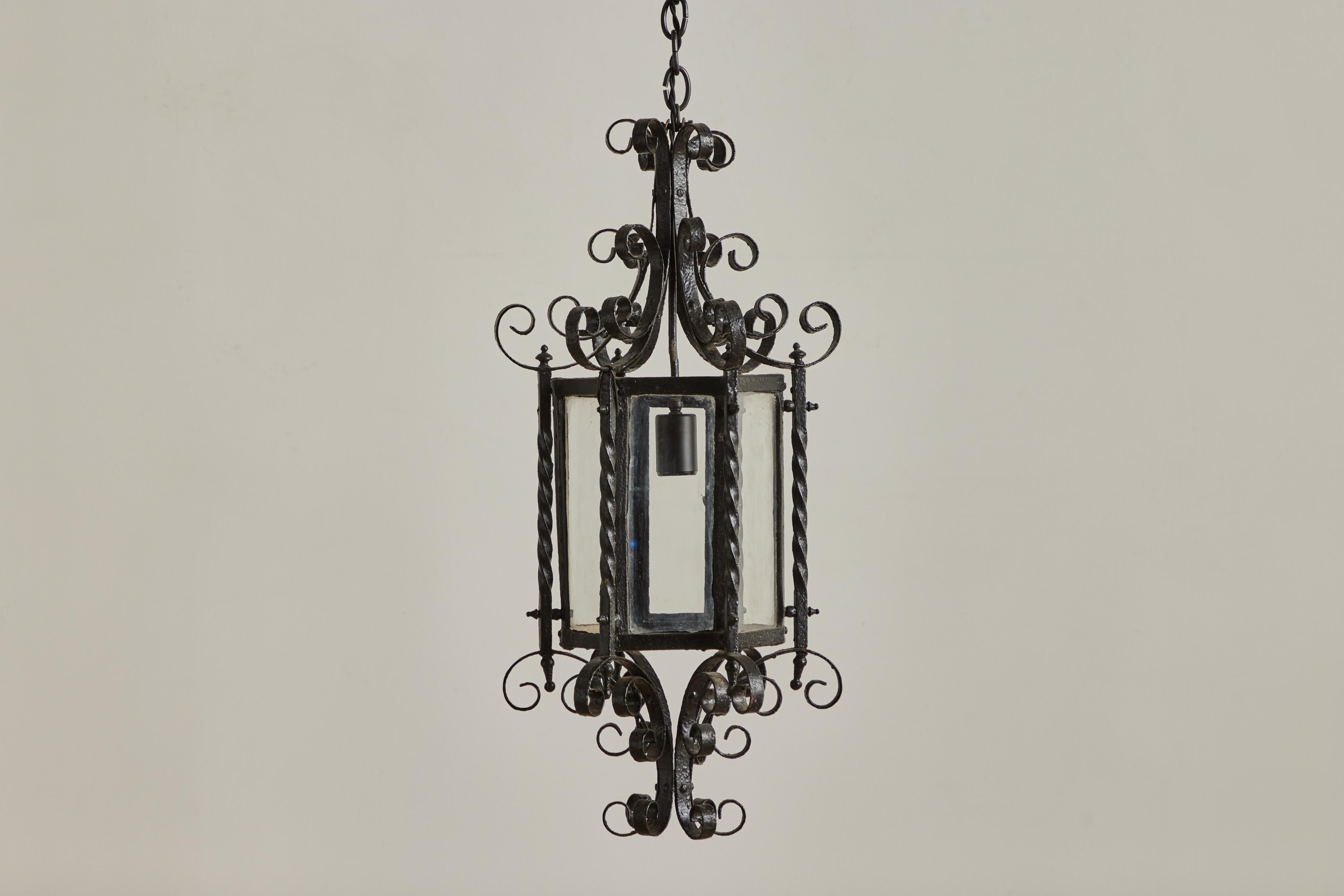 Pendentif néo-gothique en fer et en verre provenant de France vers 1940. Cette suspension a été nouvellement câblée pour une installation en dur et nécessite une ampoule E26 standard. L'usure visible sur le fer correspond à l'âge et à l'utilisation. 