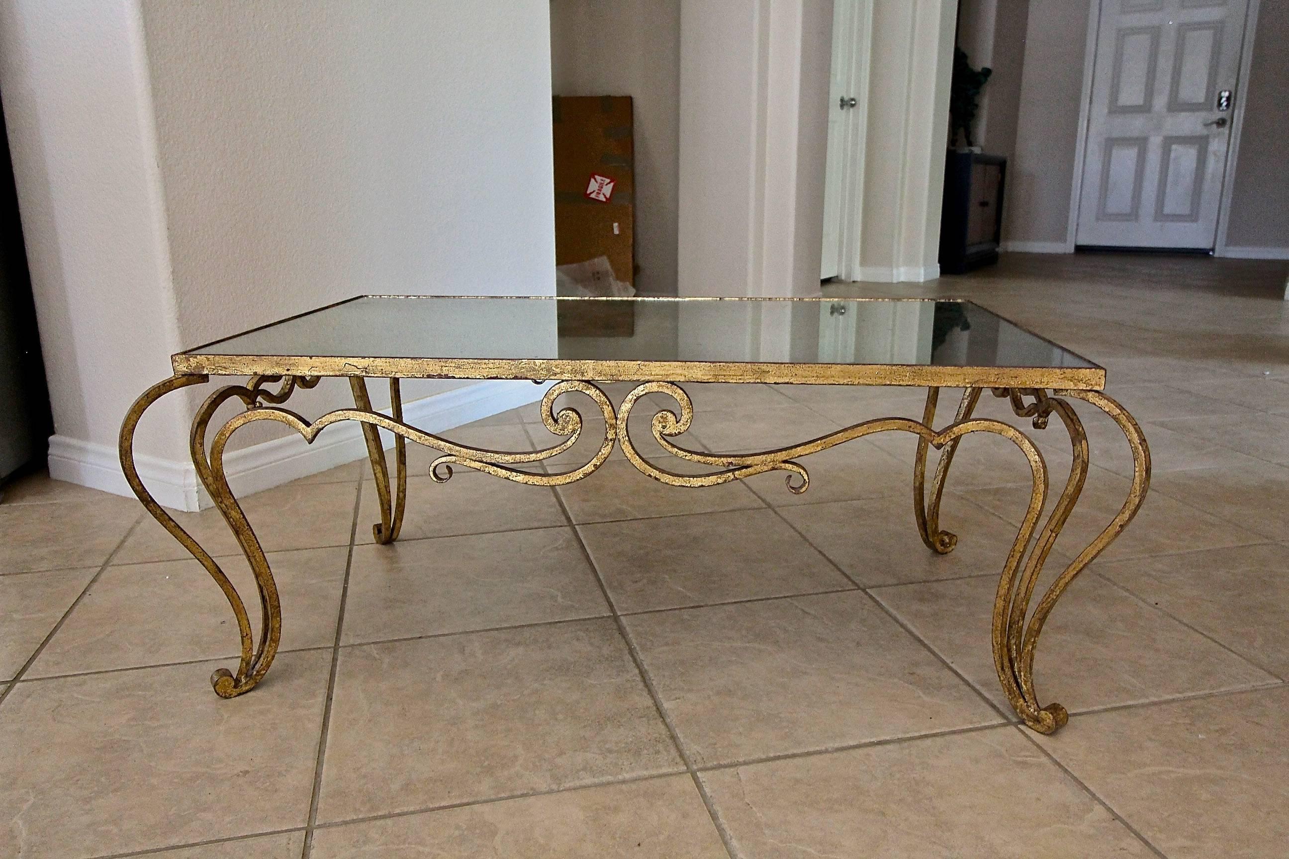 Gilt iron cocktail or coffee table in the manner of René Prou. Inset mirror top with antiqued finish.