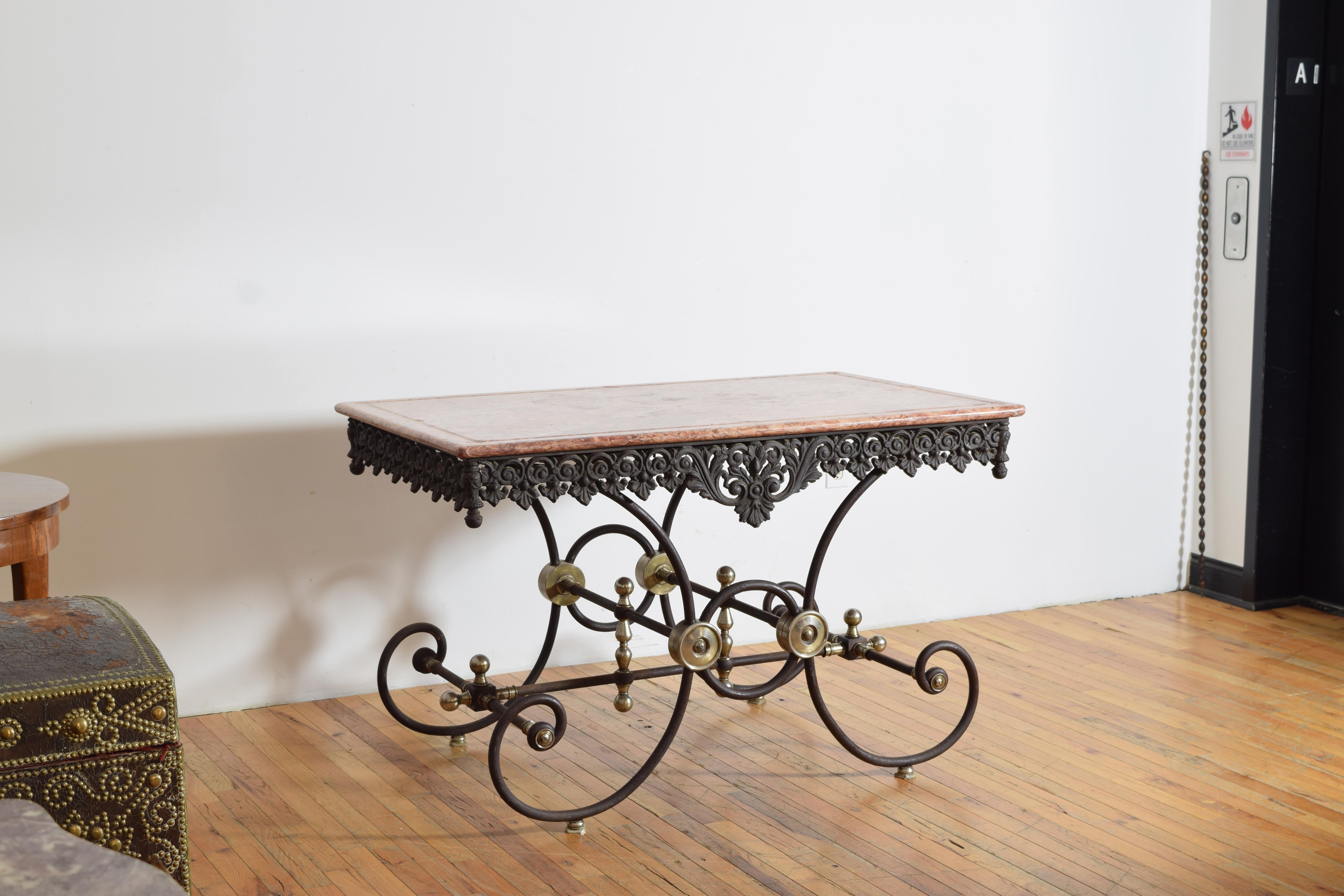 con il piano in marmo originale scanalato con bordi e punti di raccolta rotondi agli angoli e ai lati, su una struttura conforme con grembiule in ferro battuto, gambe in ferro arrotondate e terminali e medaglioni in acciaio, sollevata su piccoli