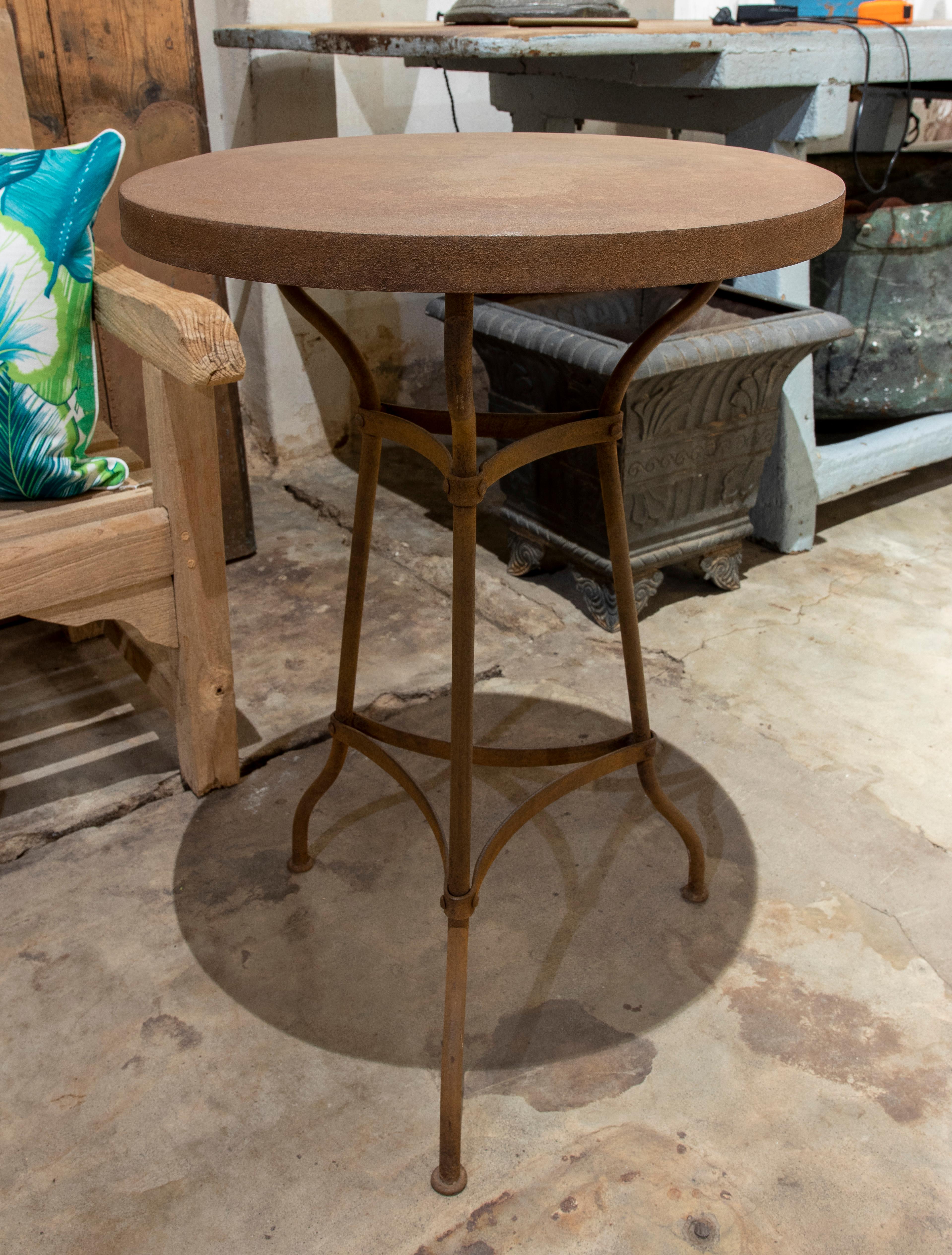 French iron table with round top and three legs for the garden.