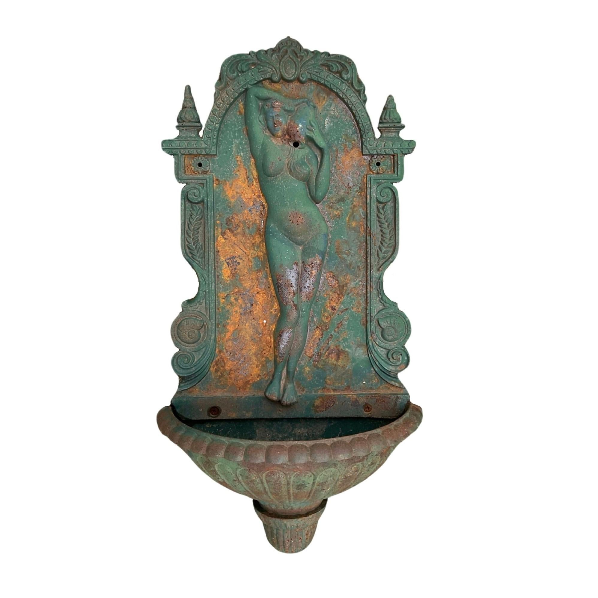 Enhance your outdoor space with a touch of French elegance. Our antique iron wall fountain from the 19th century features a beautiful carved venus sculpture, adding a rustic charm to your surroundings. The small size basin ensures a constant water