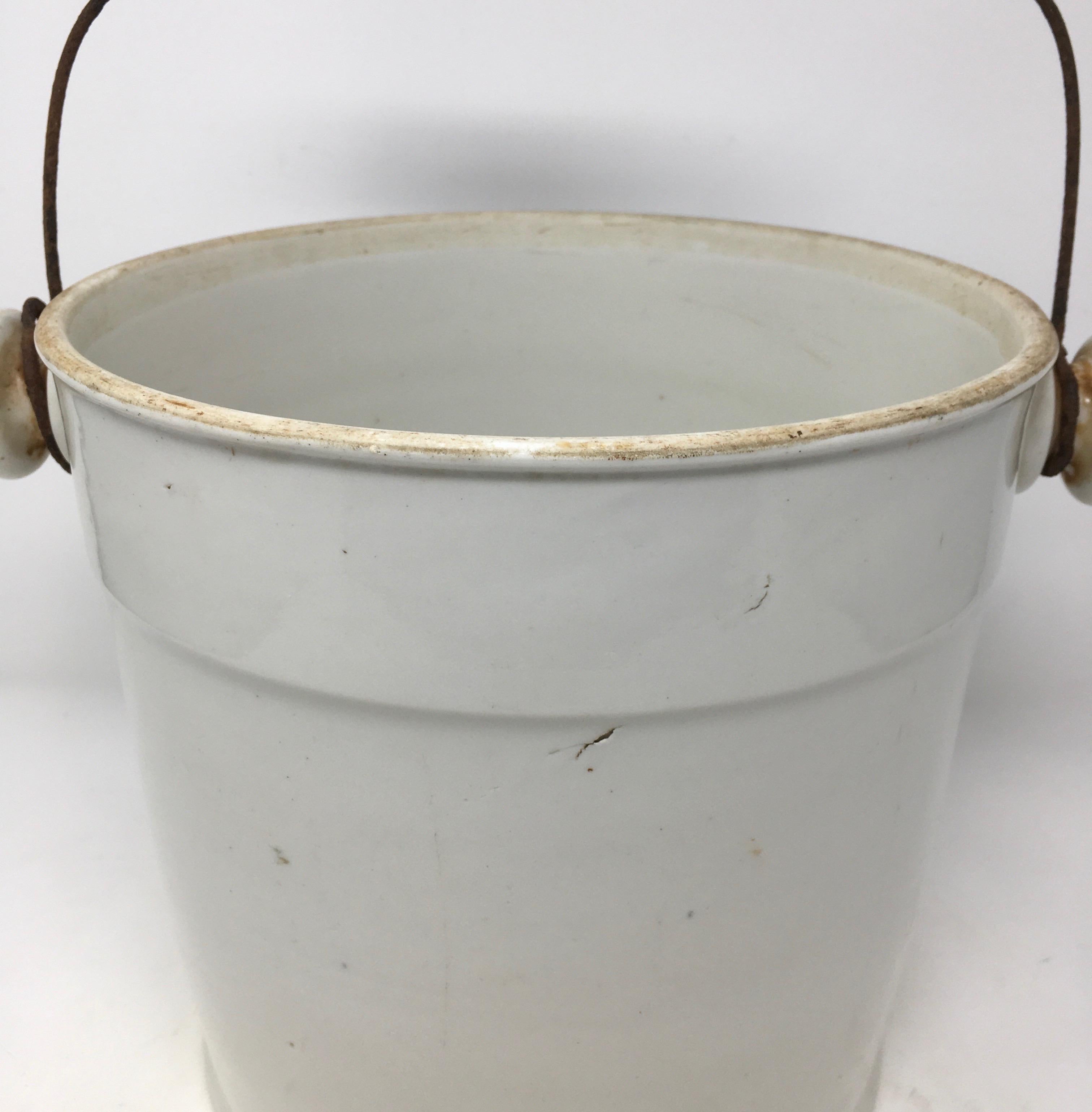 This Classic French Ironstone milk pail has a metal and wood handle. It is beautiful as is, or used to hold flowers.