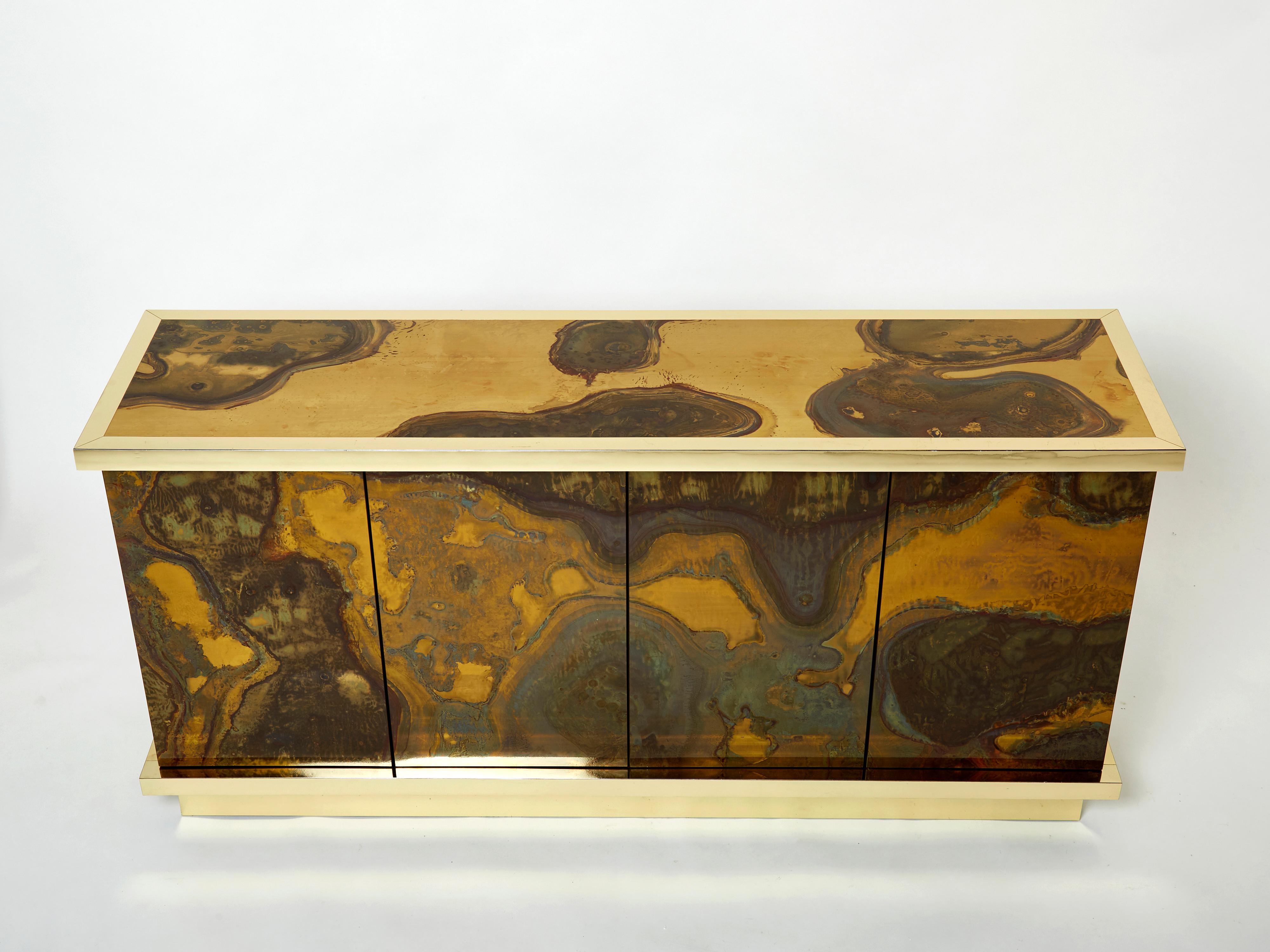 This unique sideboard was created by Isabelle and Richard Faure for Parisian design firm Maison Honore in the late 1970s. Entirely covered by decorated oxidized and patinated brass all over, that was then fixed and varnished. The base and frames are