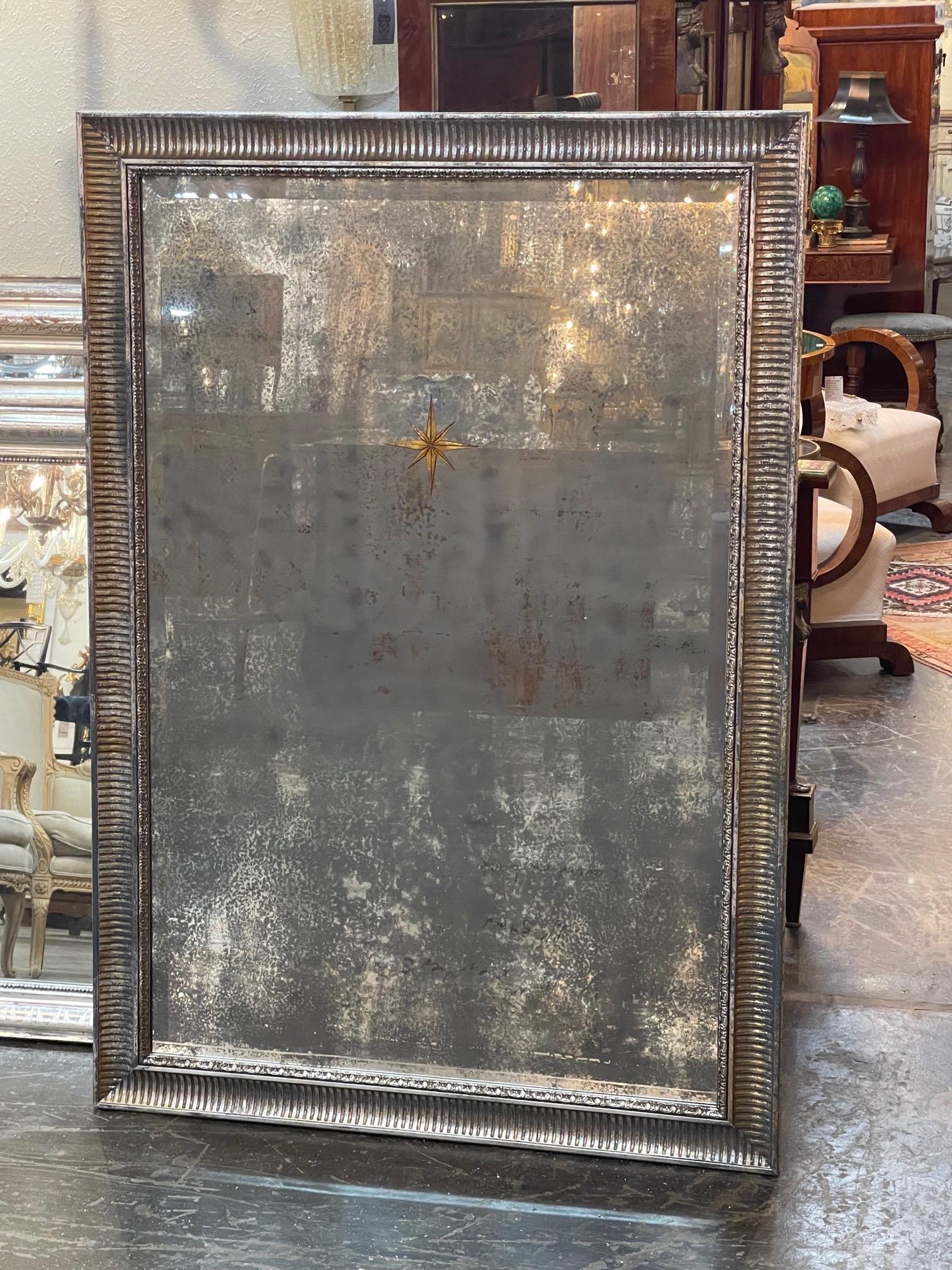 Gorgeous decorative French Jansen distressed mirror with Eglomise star. The mirror is framed with a silver leaf wood frame. Stunning!!