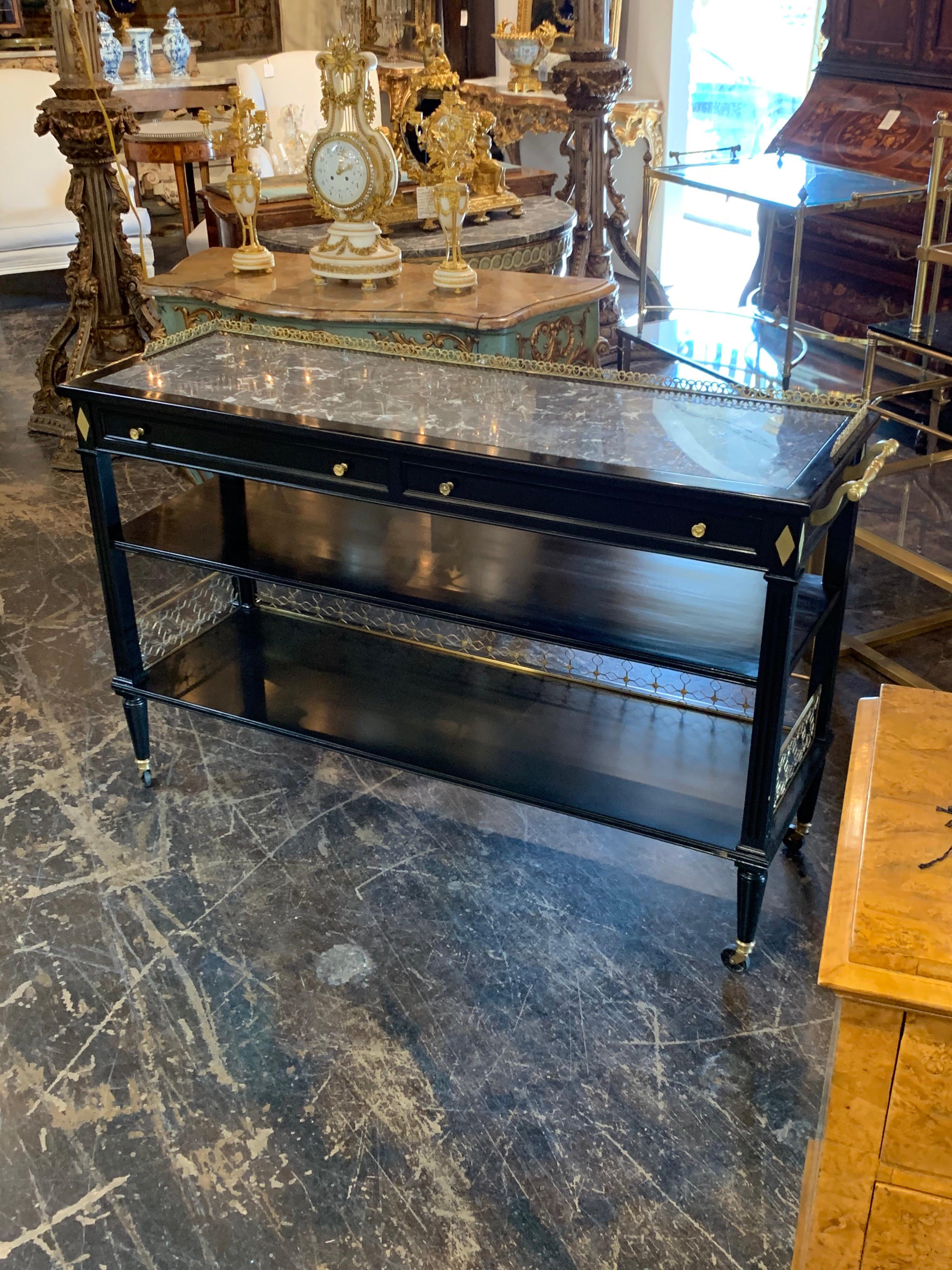 Very elegant French midcentury black lacquered server with gorgeous bronze details. It has a beautiful inset grey and white marble top. There is nice sectioned storage in the drawers. A truly stunning piece!