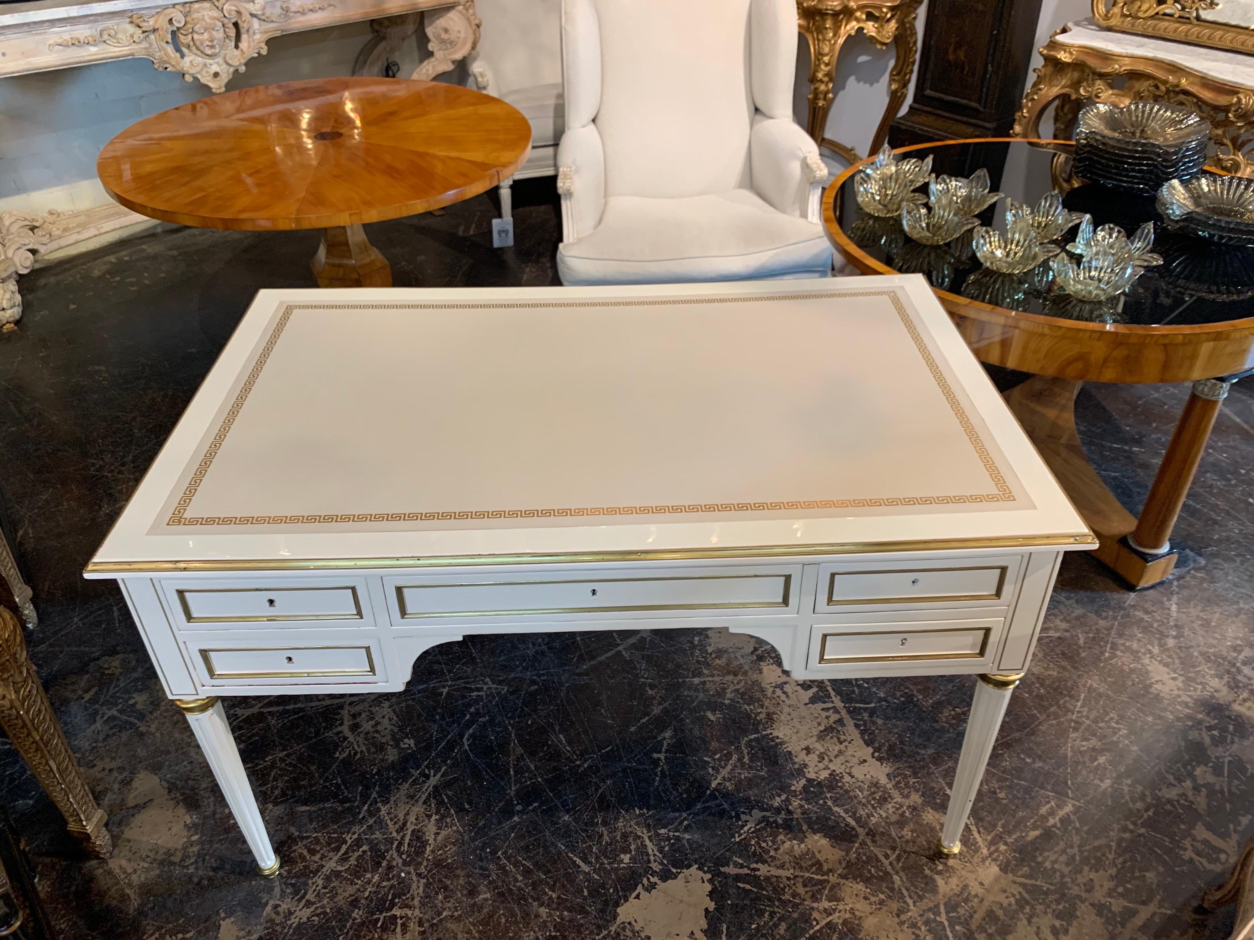 Elegant French Jansen style white lacquered and brass trim desk. Beautiful leather top with Greek key pattern.
A very polished look! Exceptional!