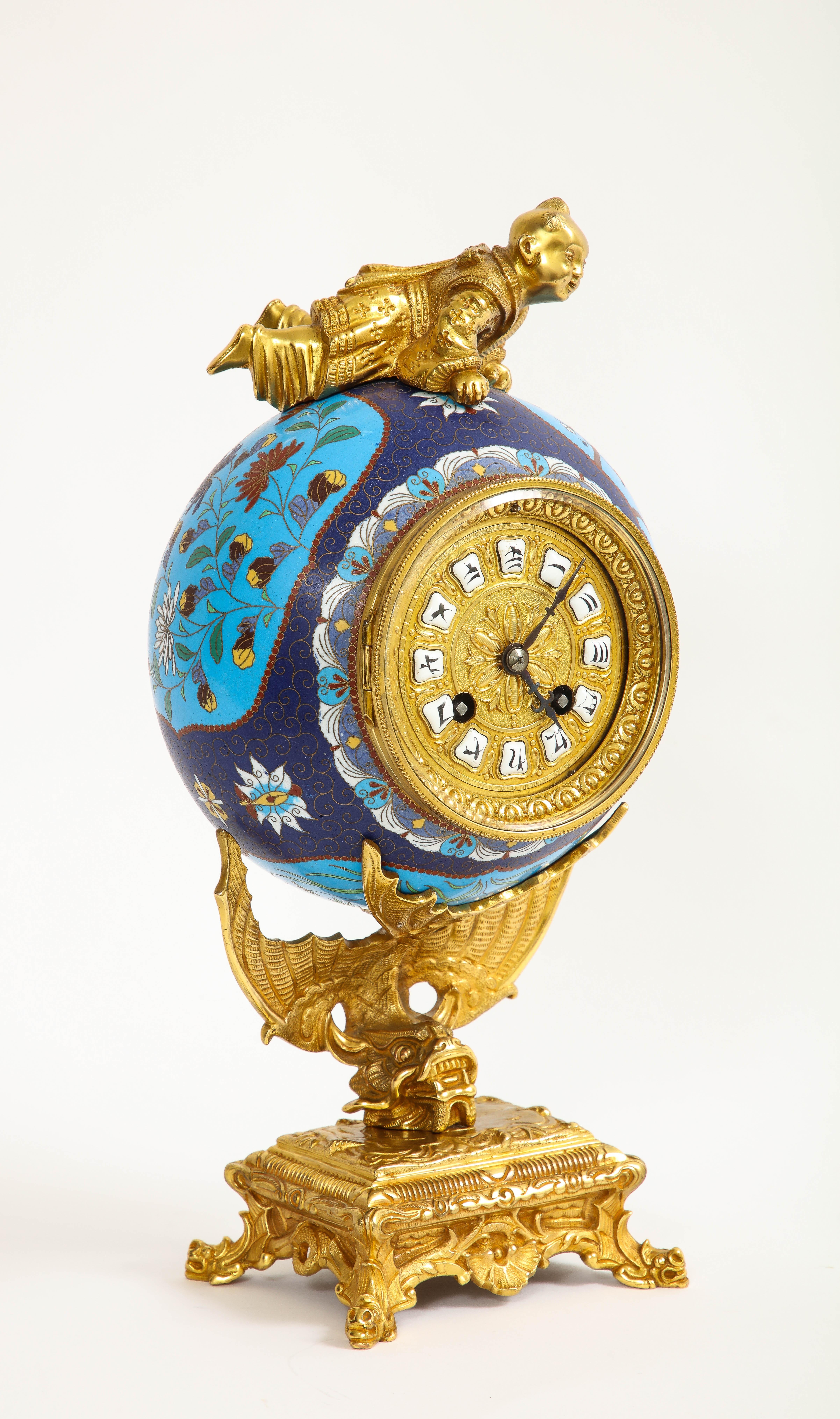 French Japanism Champlevé Enamel Ormolu Mounted Clock, Christofle & Cie.  The clock consists of a spherical champlevé enamel body mounted in an ormolu structure. The enamel surface is decorated with a combination of deep blue and turquoise