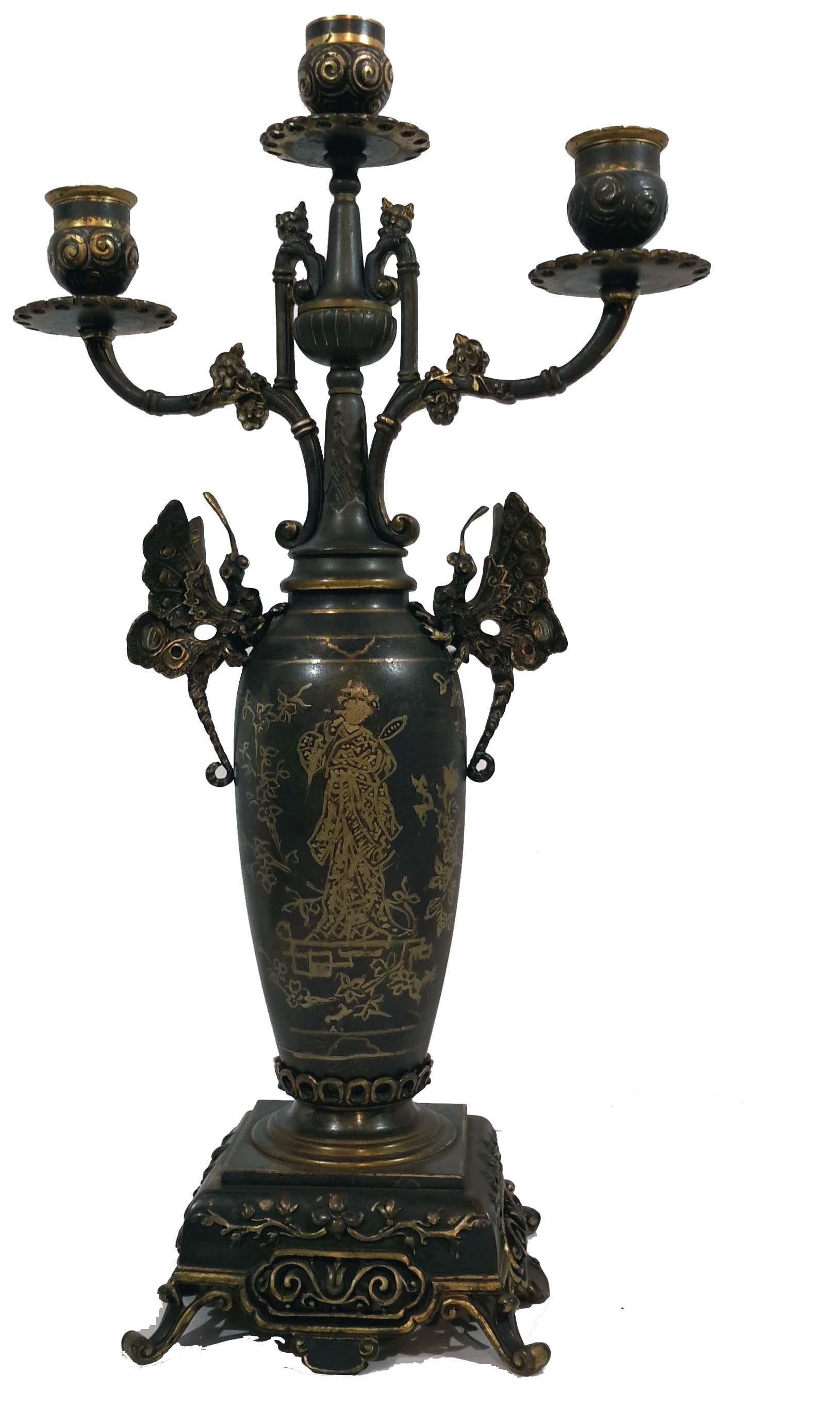 Exotic design possibly by Edouard Lievre, with butterflies and elephant feet.
Gilt decoration and patinated bronze structure.
Measures: Clock height 16 inches, width 10 inches, depth 7 inches.

Candelabra height 17 inches, width 9 1/4 inches,