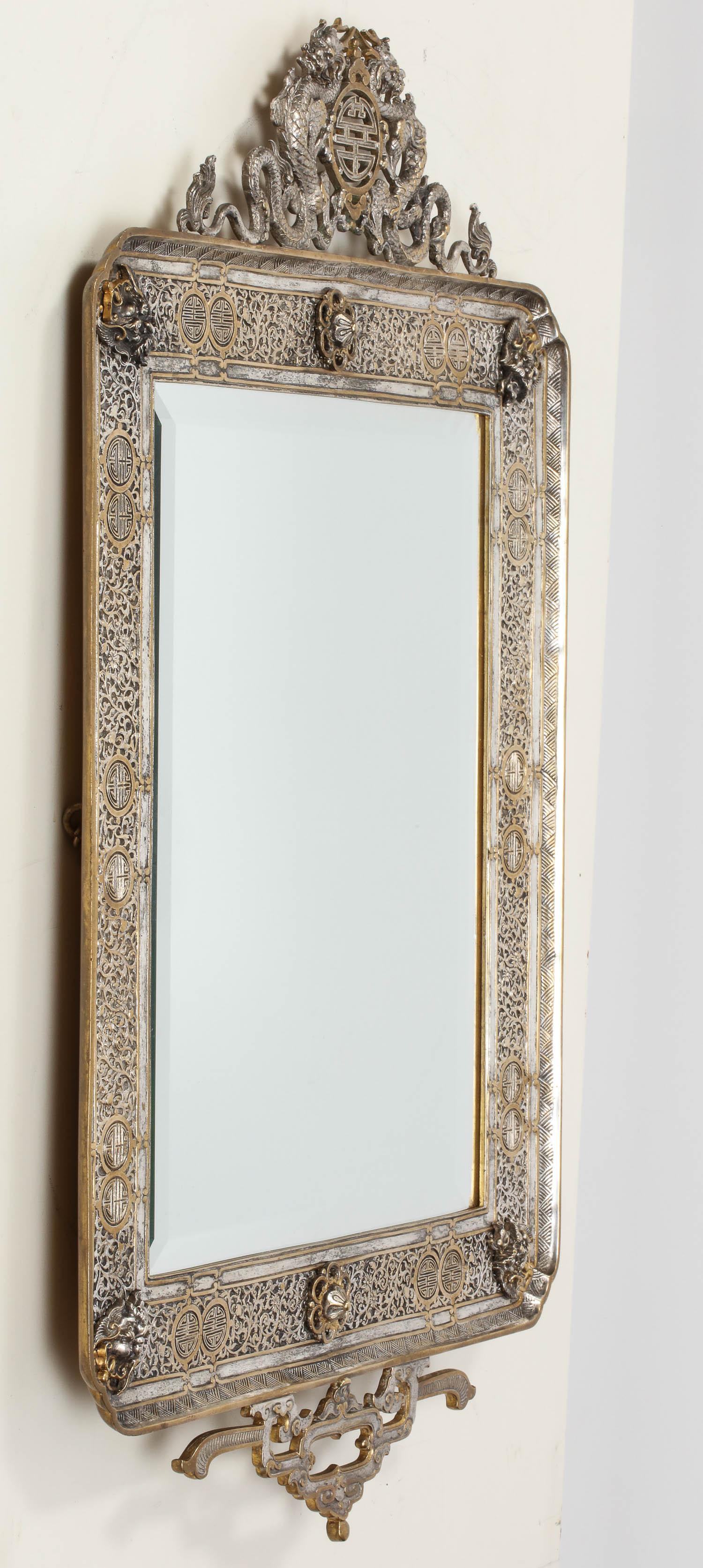 A French Japonisme Gilt and Silvered Bronze Wall Mirror by Edouard Lievre, 
circa 1880

The exquisite quality cresting is modeled as dragons, high quality mask heads and centered by a roundel above a rectangular beveled glass mirror.

Measures: