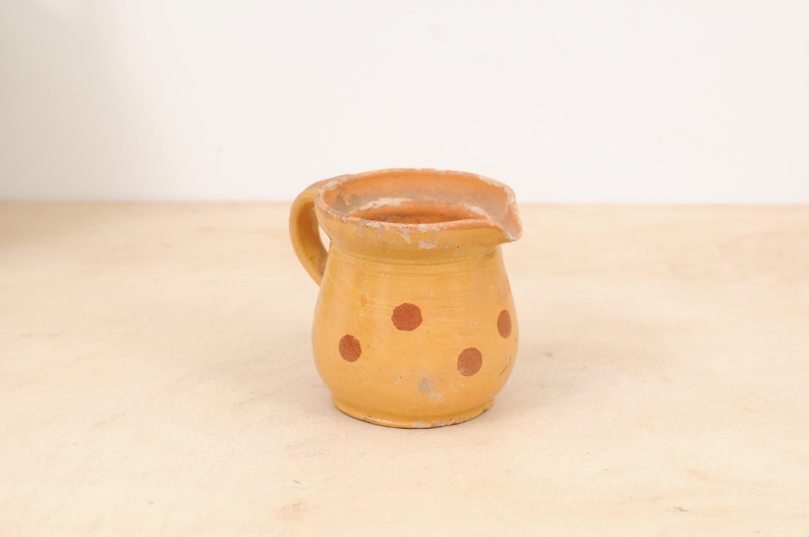 A French jaspe ware pottery pitcher from the 19th century, with yellow glaze and rust polka dots décor. Created in France during the 19th century, this French jaspe pitcher attracts our attention with its yellow glaze, simply adorned with rust polka