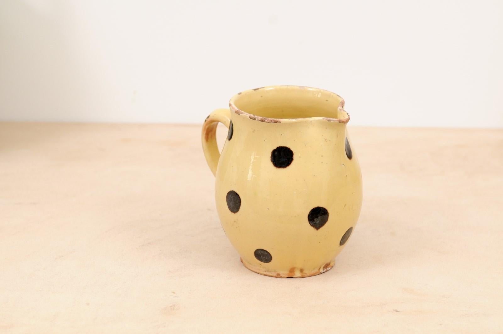 A French jaspe ware pottery pitcher from the 19th century, with pale yellow glaze and brown polka dots décor. Created in France during the 19th century, this French jaspe pitcher attracts our attention with its pale yellow glaze, simply adorned with