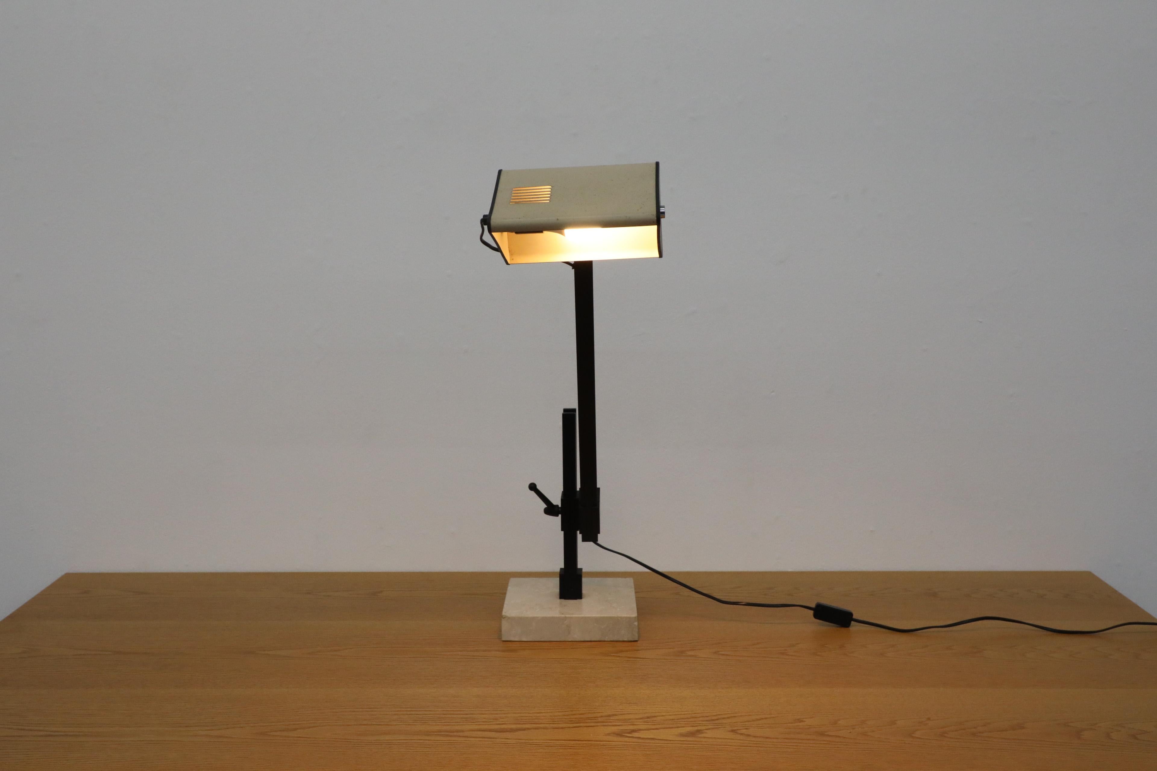 Lámpara de sobremesa francesa de mediados de siglo, de la década de 1970, diseñada en un estilo influenciado por Jean Prouvé. La pantalla de metal esmaltado en beige y negro presenta un detalle de lamas que recuerda en cierto modo a las ventanas de