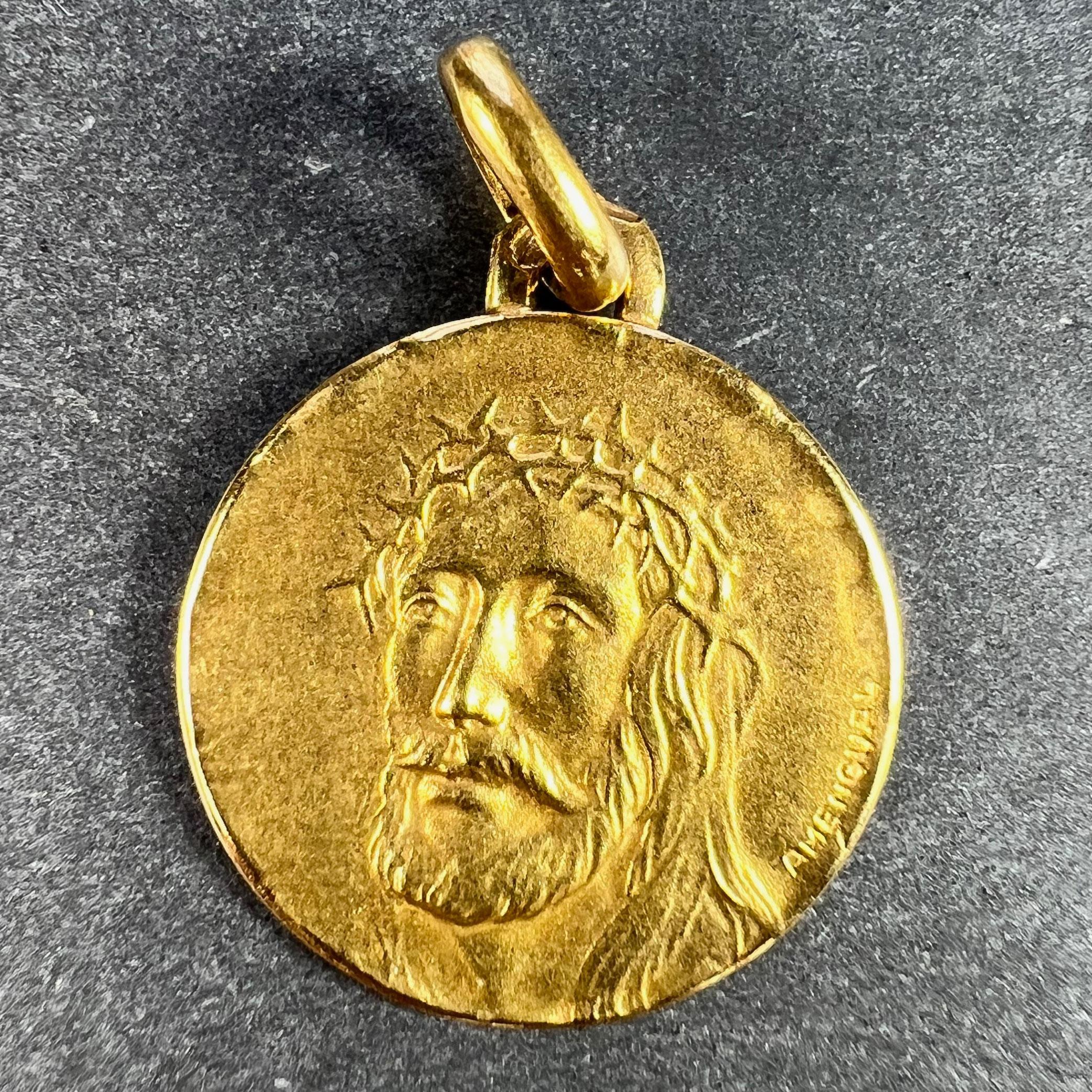 Pendentif à breloques français en or jaune 18 carats (18K) conçu comme une médaille ronde représentant le visage de Jésus-Christ portant la couronne d'épines. Signé Amengual, estampillé de la tête d'aigle pour l'or 18 carats et de fabrication