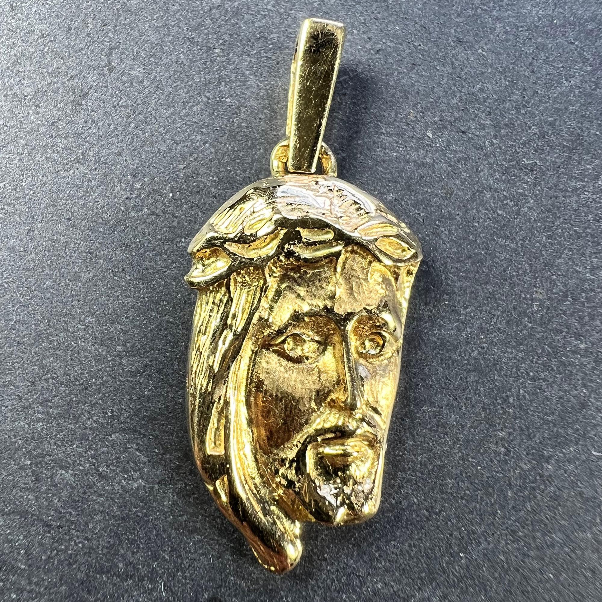 A French 18 karat (18K) yellow gold charm pendant designed as a sculptural three-quarter profile of Jesus Christ wearing the Crown of Thorns. Tested for 18 karat gold and stamped with an unknown maker's mark.

Dimensions: 2.6 x 1.5 x 0.34 cm (not