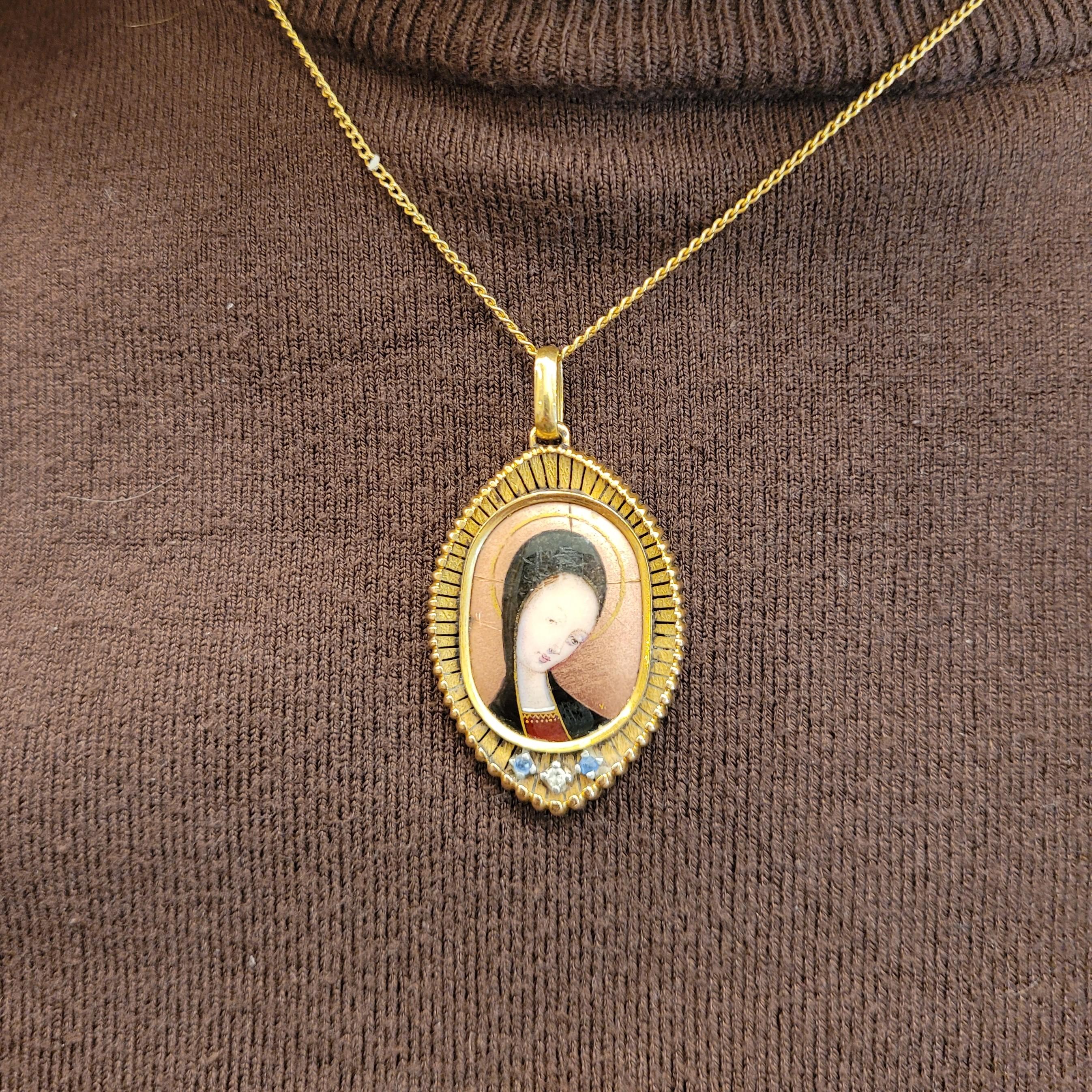 One of a kind  and exclusive sterling gold pendant, Frances, an exquisite piece of pre-owned jewelry from the early 20th century. The pendant features a beautiful hand-enameled portrait of the Virgin or Madonna in an oval shape, capturing the