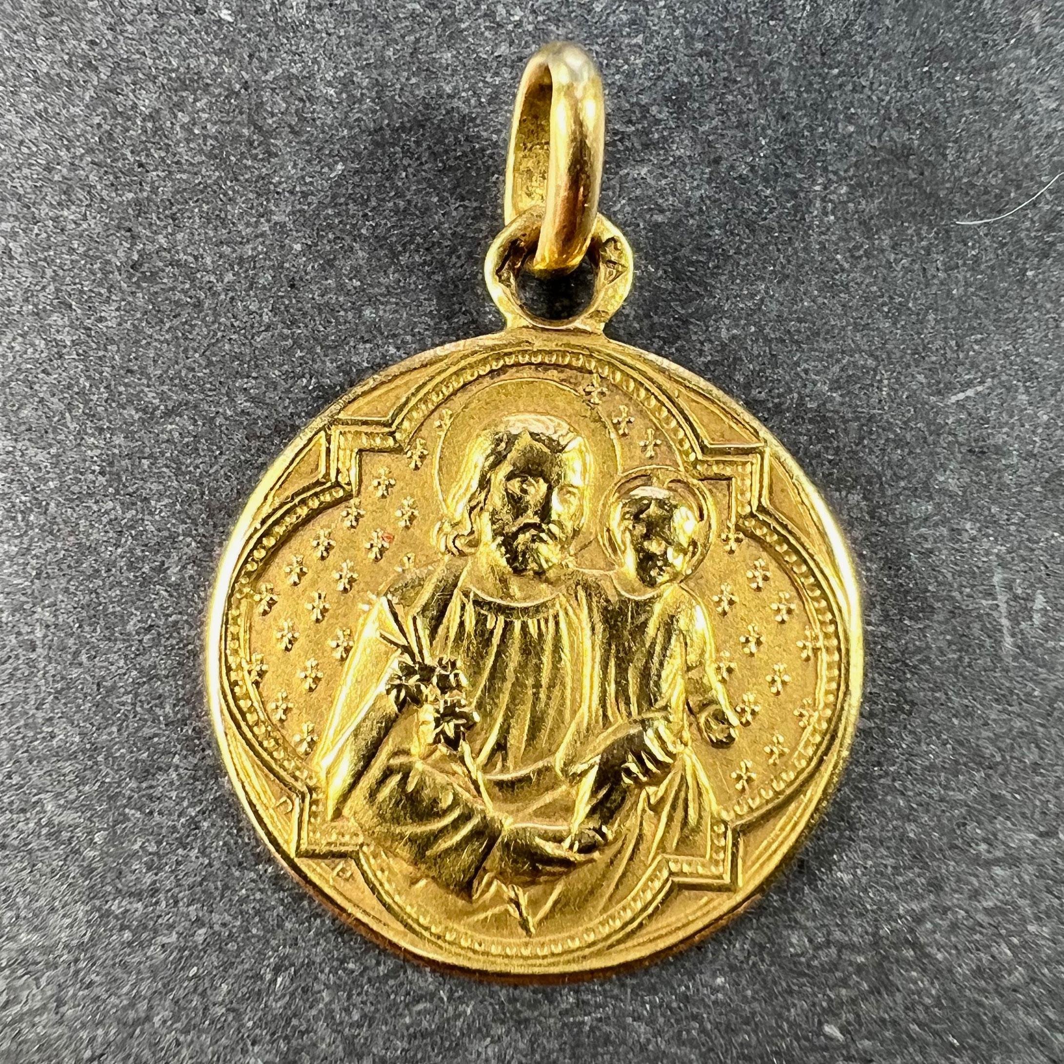 Pendentif à breloques en or jaune 18 carats (18K) conçu comme une médaille ronde représentant Saint Joseph avec l'enfant Jésus Christ dans un cadre gothique. Le même cadre gothique au revers et gravé 
