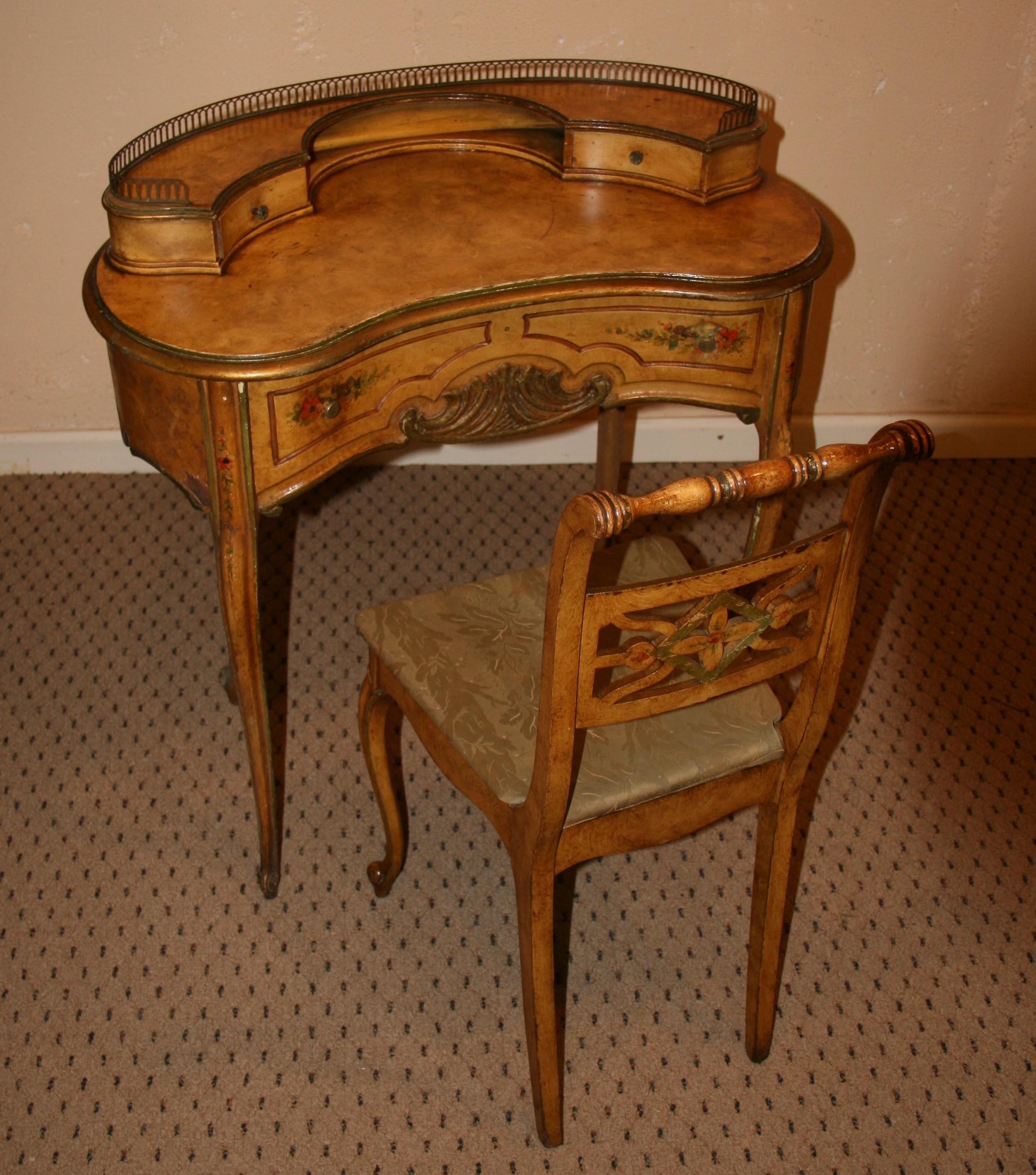 3-1072 Kidney shaped desk and matching chair with hand painting and carved detailing
Brass railing and two small drawers and large center drawer.
Chair 34