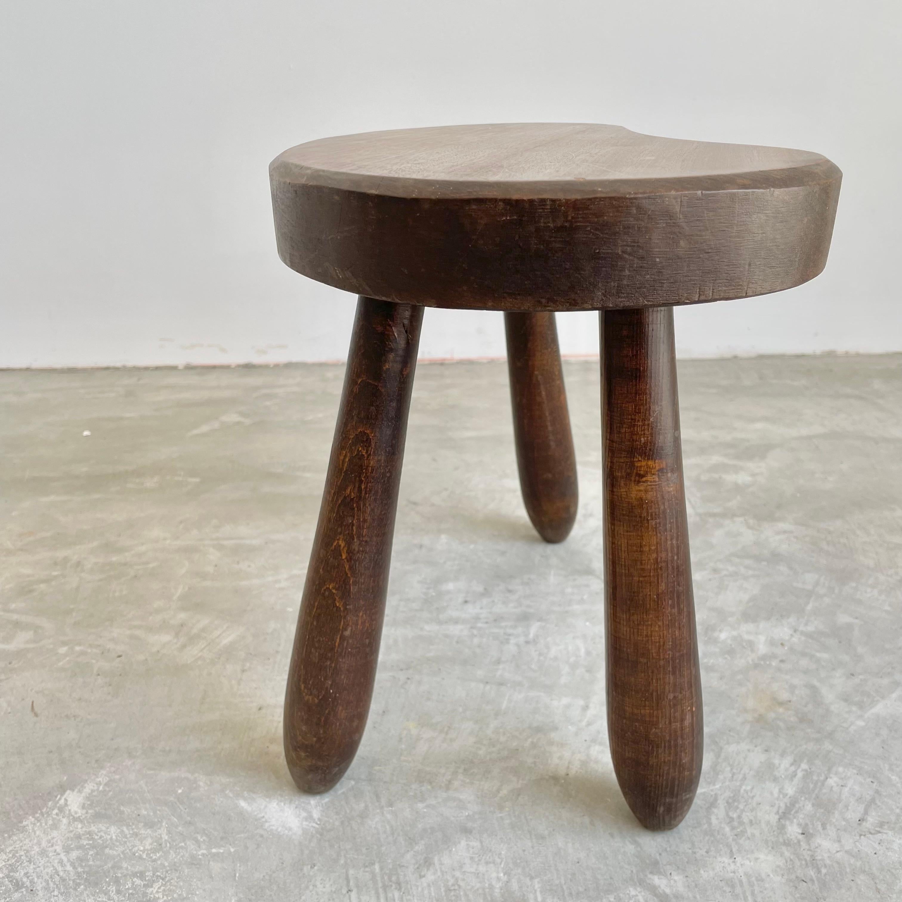 Beautiful wooden stool made in France, circa 1950s. Substantial and chunky, this stool has beautiful lines and solid craftsmanship to club legs. Great patina and grain to the wood. Excellent petite shape. Perfect for books or objects.
 