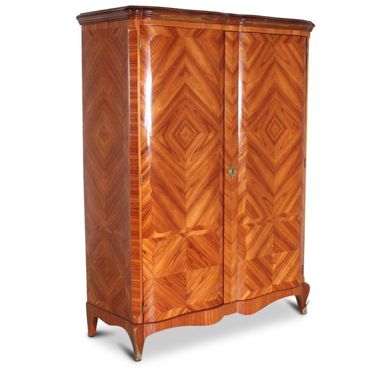 A French, two-door armoire with dramatically-figured book-matched kingwood veneering to the doors and sides. The piece is fitted with four adjustable shelves but could be fitted with a rod for hanging clothes. The doors and sides are shaped with a