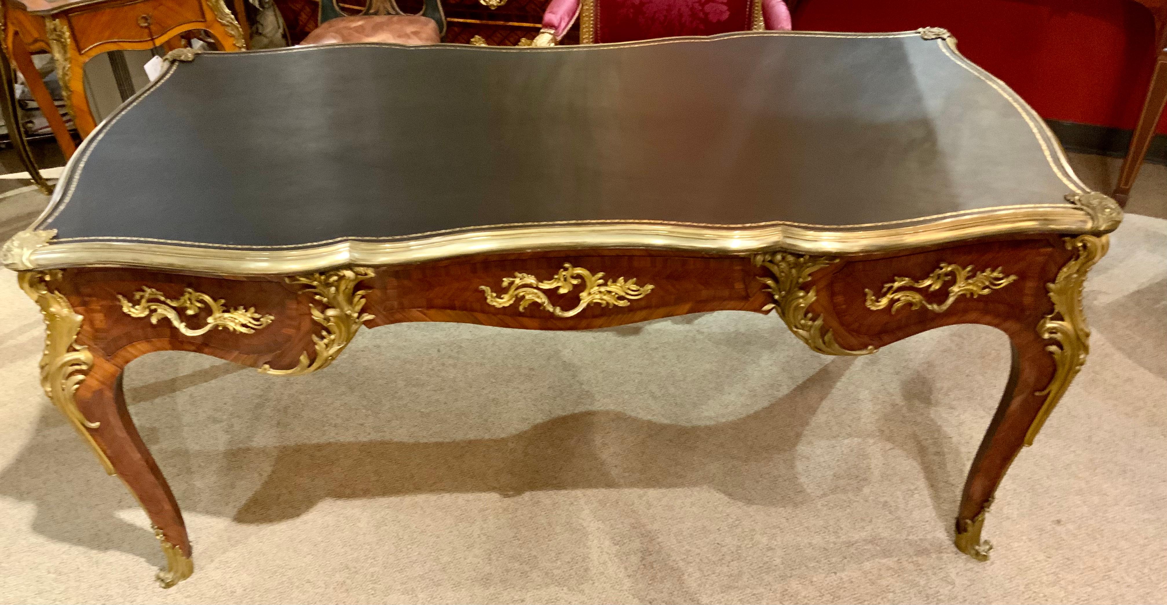 This desk is 19 th century and has the original aged patina. The writing surface is rectangular and has a new black leather
 With gilt accents that has been added to the top.
The writing surface is above a conforming frieze fitted with three