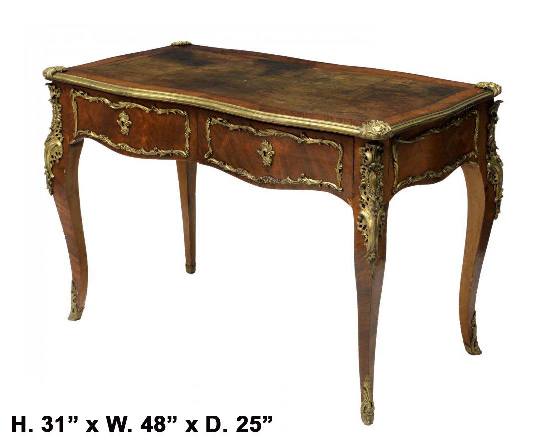 Impressive 19th century French Louis XV style Kingwood bureau plat desk.

The serpentine shaped top is inset with a tooled writing surface and a gilt bronze border, over a beautifully veneered Kingwood frieze, the front fitted with two