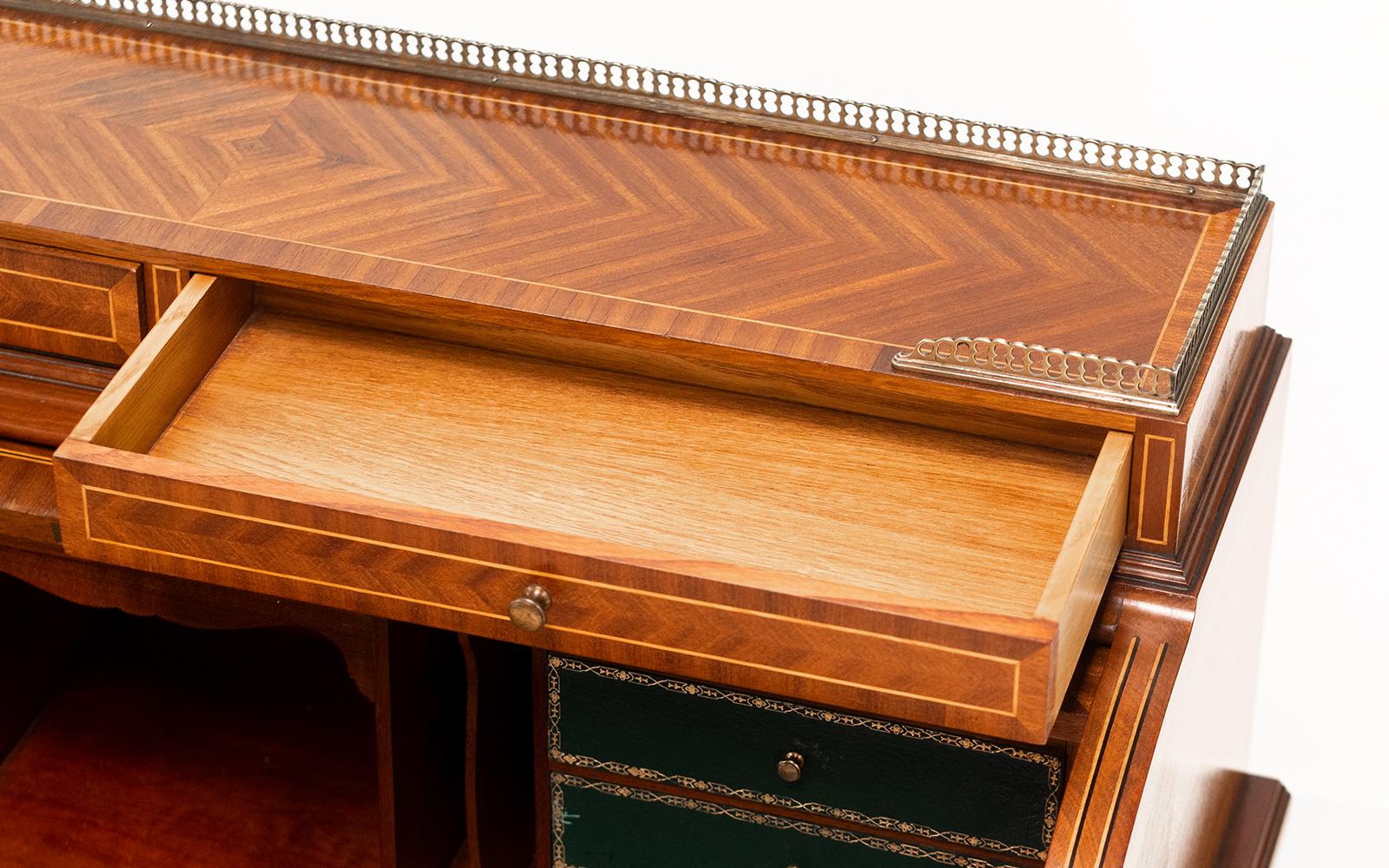 French Kingwood desk

A roll-top French kingwood and mahogany cylinder desk.

As you lift the roll-top front, the desk automatically slides out to reveal the leather work surface and drawers above.

Pierced gallery top gallery, on four