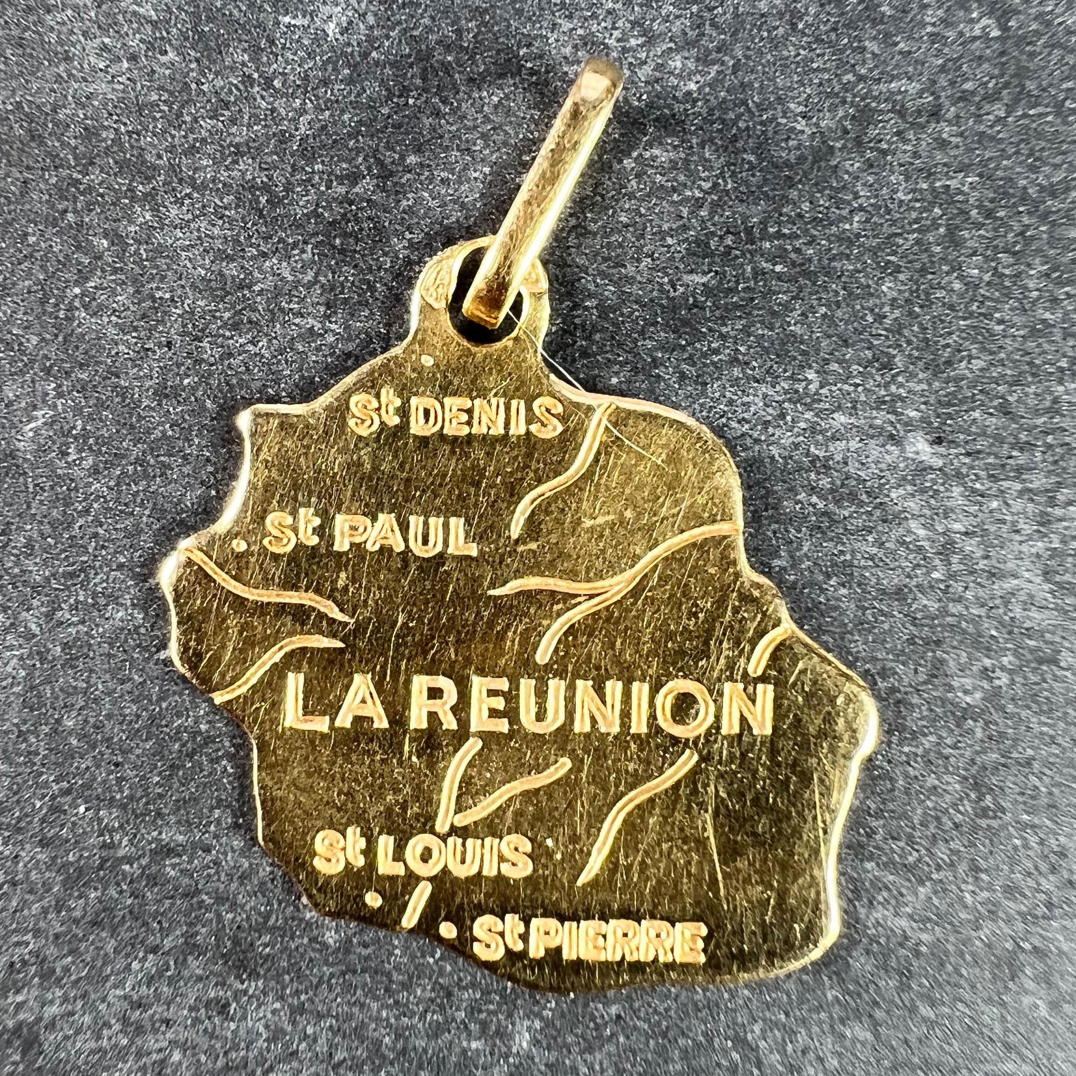 A French 18 karat (18K) yellow gold charm pendant designed as a map of the island of Reunion with the towns of St. Denis, St. Paul, St. Louis and St. Pierre marked on it. Stamped to the bail with the eagle's head mark for French manufacture and 18