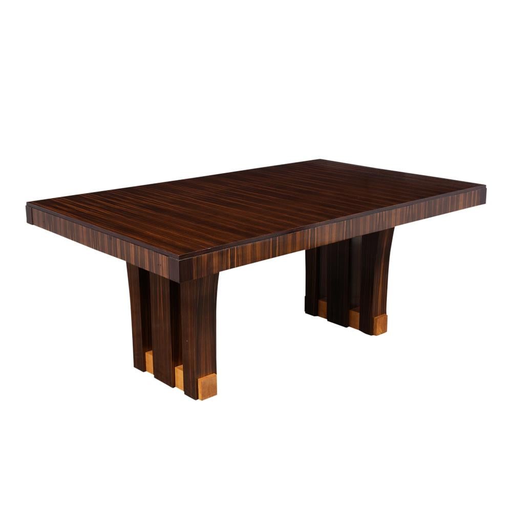 This Beautiful French Art Deco Style Dining Table is made of Macassar wood with a newly lacquered finish and is in great condition. The simple wood tabletop is accentuated by unique pedestal legs where the legs are separated into three parts