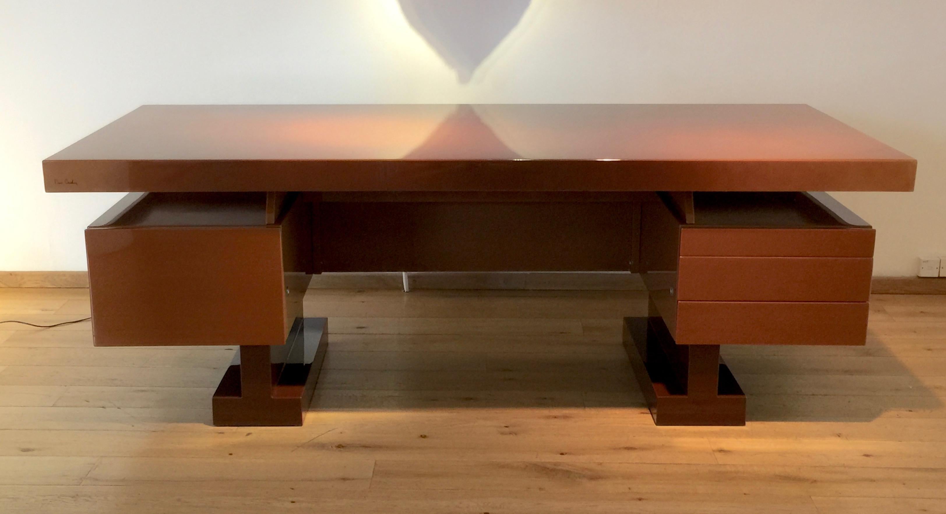 An extremely handsome desk designed by Pierre Cardin. The strong geometric volumes are enhanced by the luxurious caramel lacquer finish. A single deep drawer on the left, three shallow drawers on the right (the top one fitted for pens, etc).