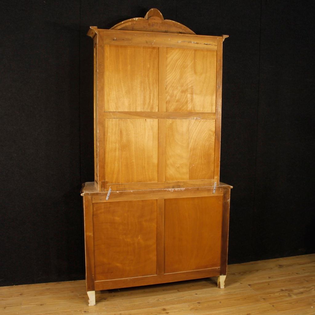 Large French showcase from the 20th century. Library in richly carved wood, lacquered, painted and
gold. Mobile built with double body to facilitate transport and insertion in the home. Lower body with four drawers of excellent capacity and