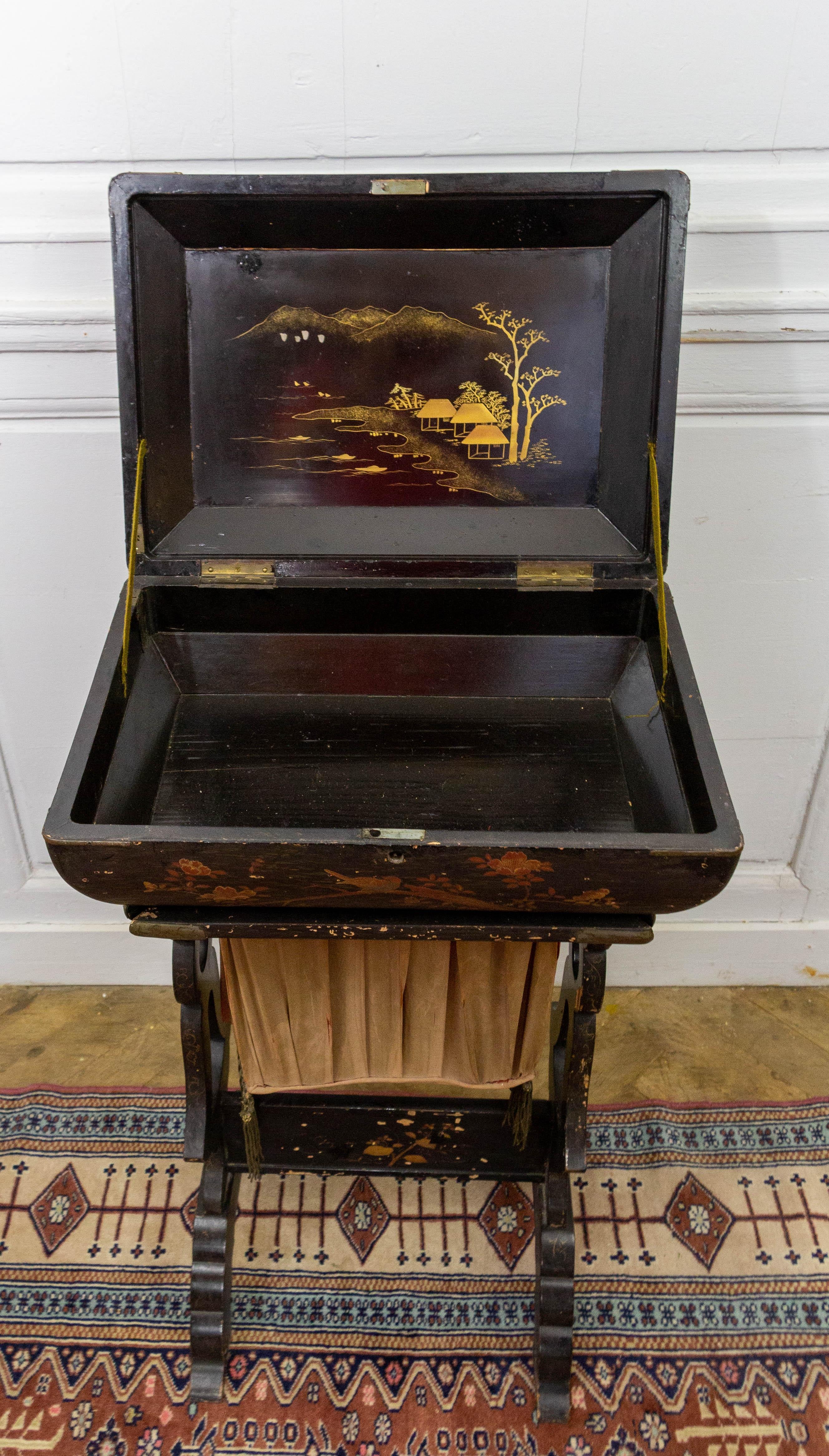 This Asian-inspired lacquered wooden work table is a beautiful expandable sewing box covered with lacquer on all sides. On the upper part, intended to receive the sewing material, the sides are decorated with birds, branches and flowers. The top is