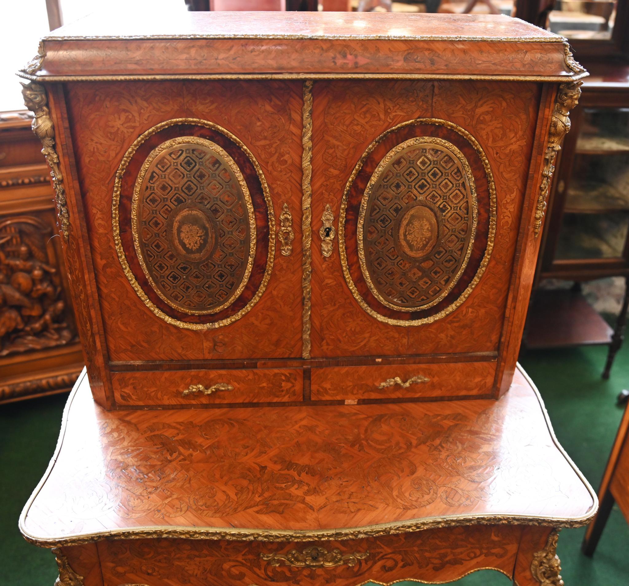 Splendido scrittoio da donna in noce francese di alta gamma con intarsi in legno
La porta è incastonata con pannelli ovali di alta qualità circondati da cornici in ormulo.
Sormontato da varie montature in ormulo tra cui busti di fanciulla
circa