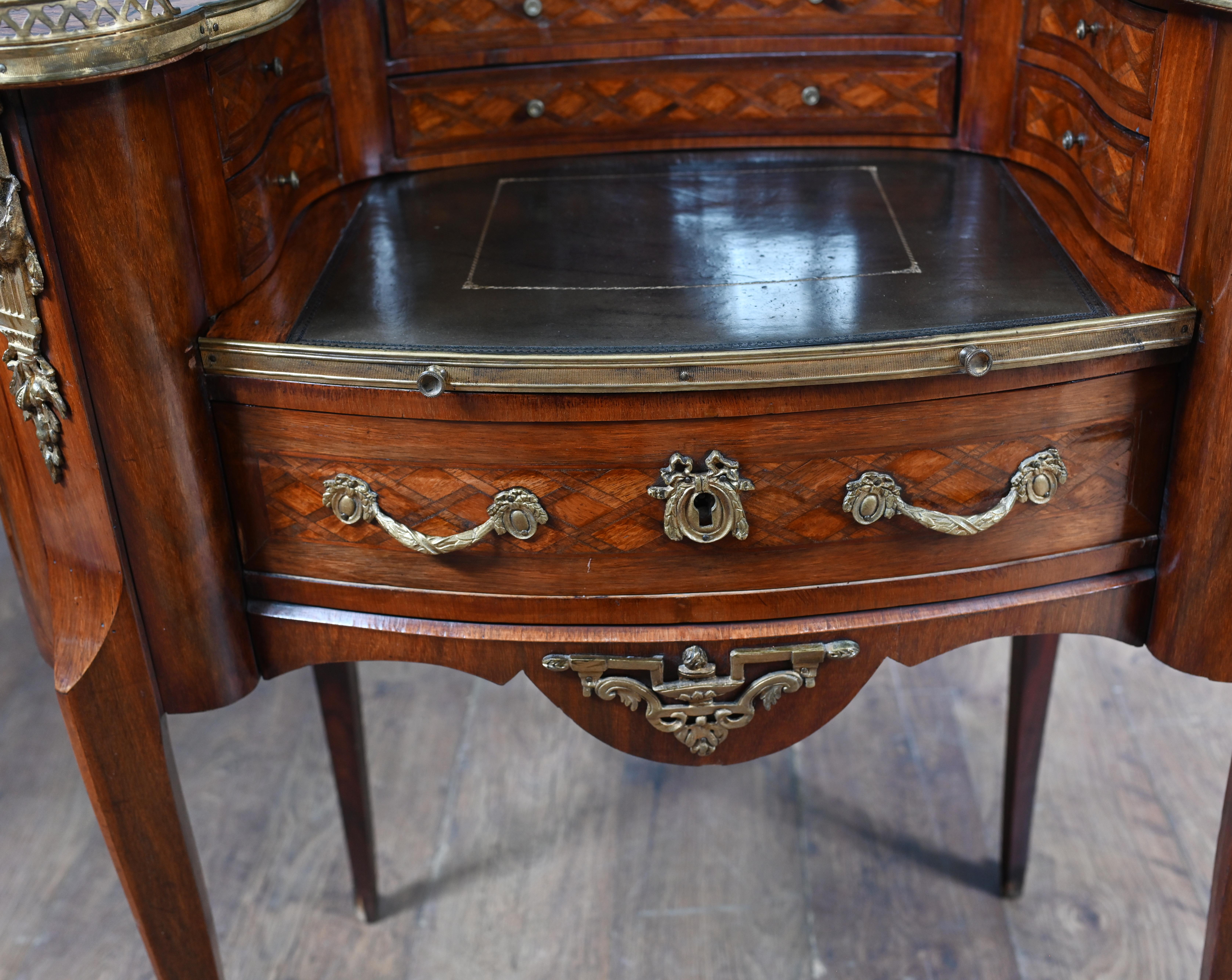 You are viewing a gorgeous French ladies desk of kidney bean form The desk is Louis XV-style and features parquetry inlay work to the top, back and sides
Lavish anbd original gilt bronze mounts embellish the piece, including classical motifs like