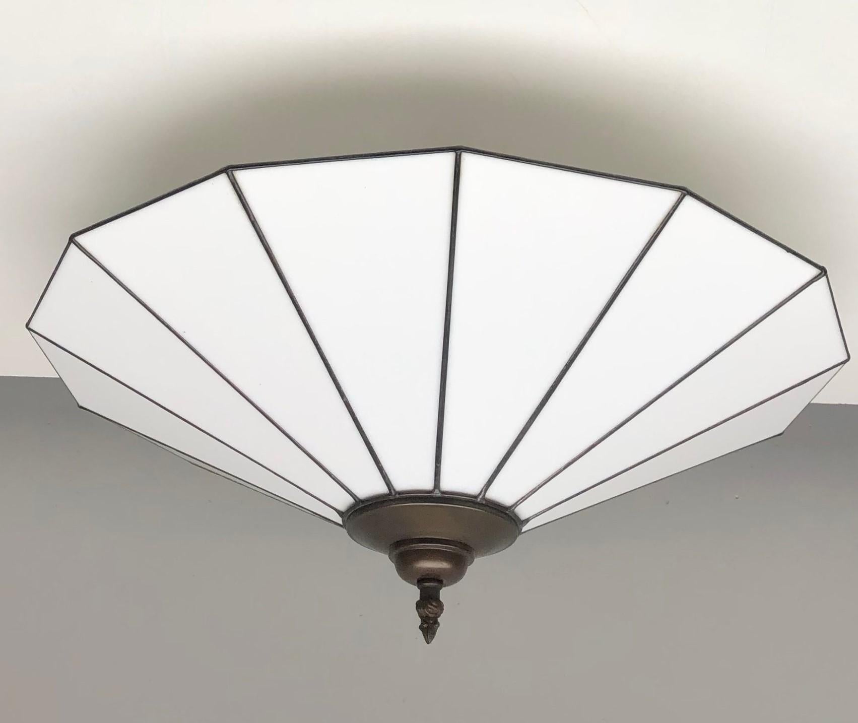 A large Art Deco leaded glass ceiling lamp with bronze mounts, France 1950s. Beautiful large conical milky white glass shade reflecting a pleasant, atmospheric light. In very good conditon, no damages, rewired. It takes two E27 large sized screw