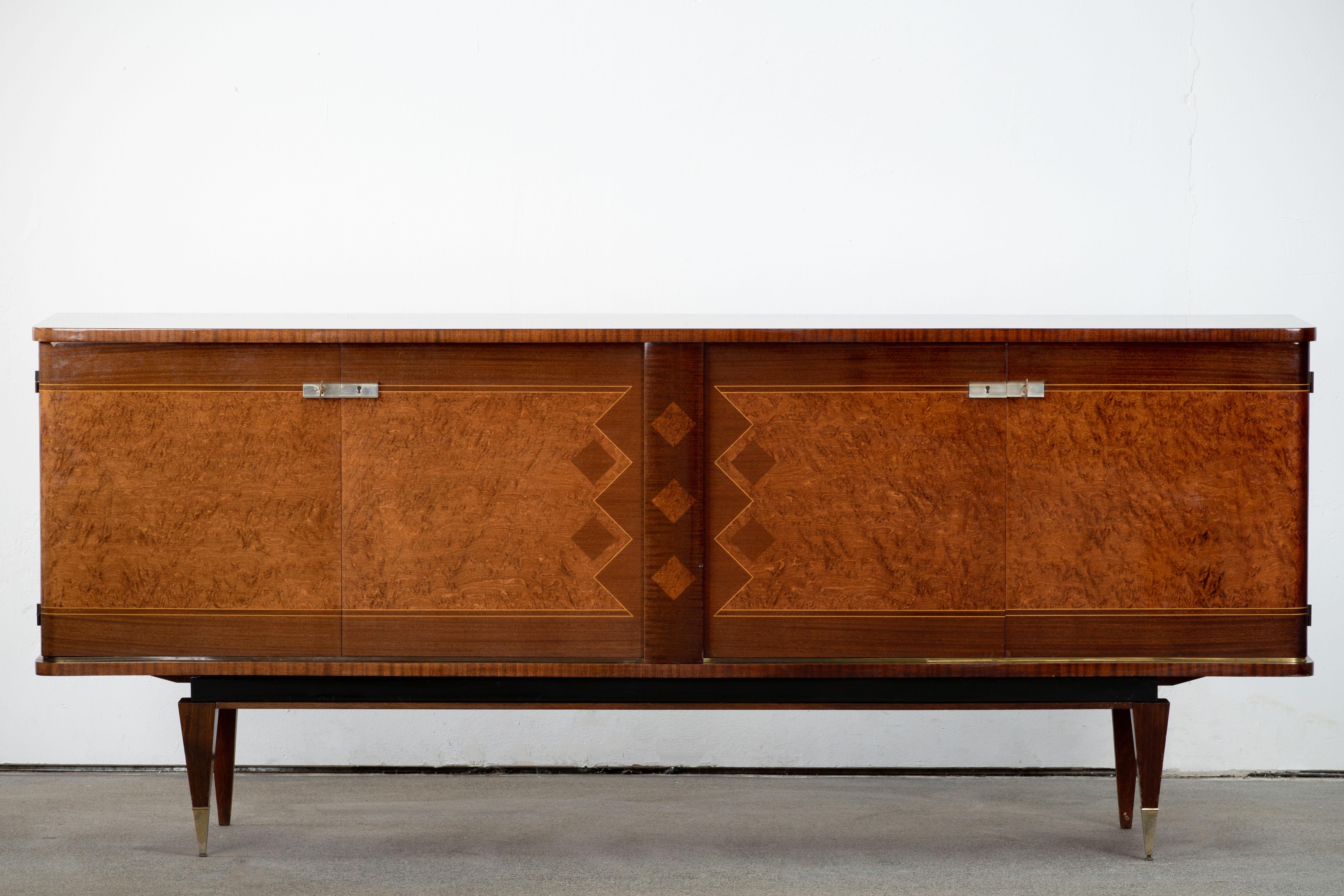 French Art Deco sideboard, credenza. The sideboard features stunning Elm Burl wood grain with a geometric pattern in the center. It offers ample storage, with shelve behind the doors. Both sides of the cabinet lock, and two keys are included. The