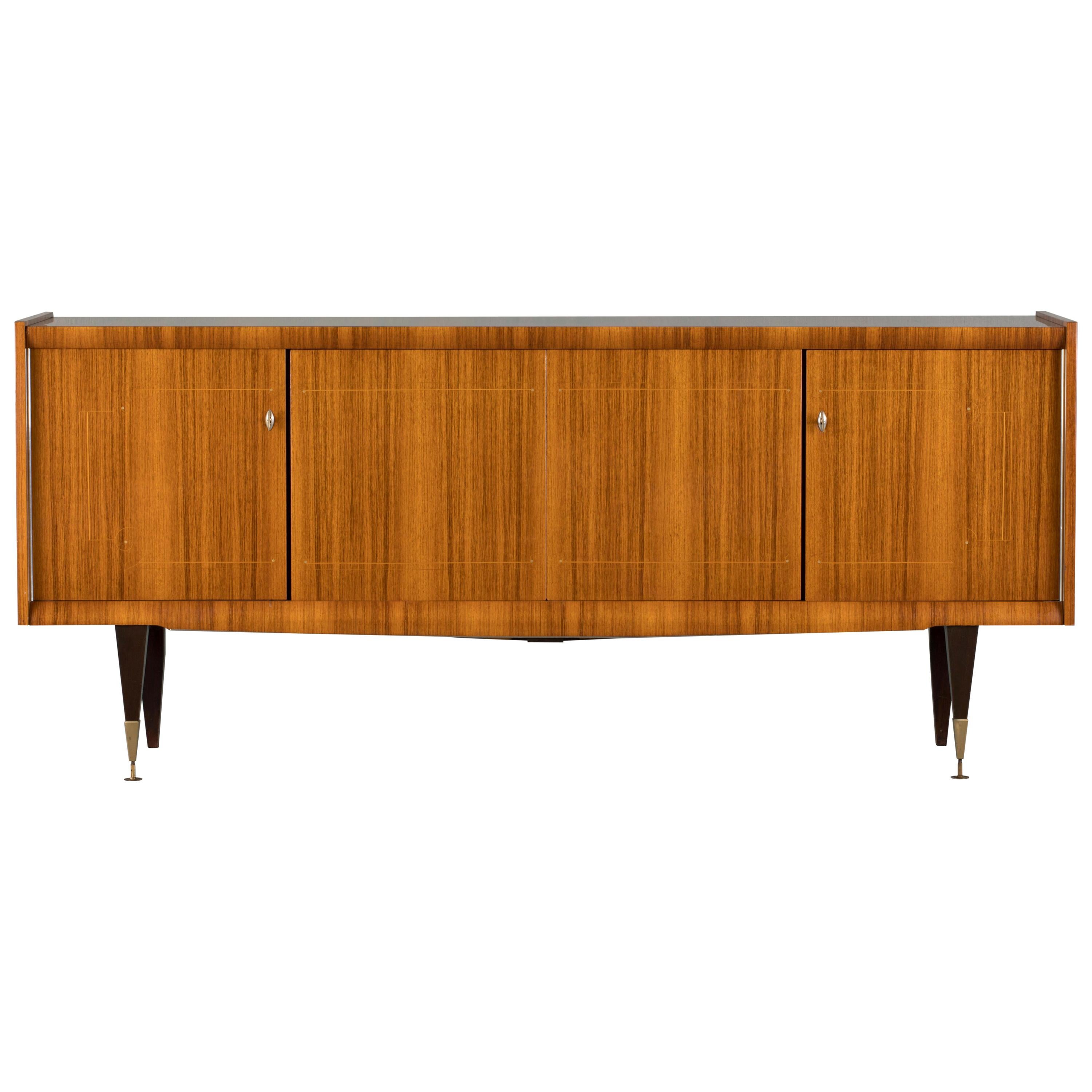 French Art Deco sideboard, credenza, with bar cabinet. The sideboard features stunning Macassar ebony wood grain with a thin decorative mother of pearl inlaid design. It offers ample storage, with shelve behind two doors on the left and a dovetailed