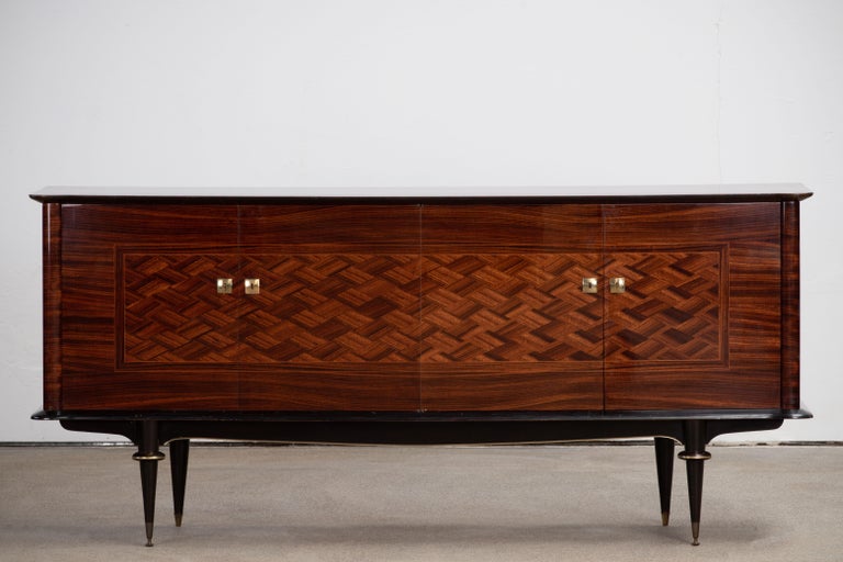 French Art Deco sideboard, credenza. The sideboard features stunning Macassar wood grain with a geometric pattern in the center. It offers ample storage, with shelve behind the doors. Both sides of the cabinet lock, and two keys are included. The