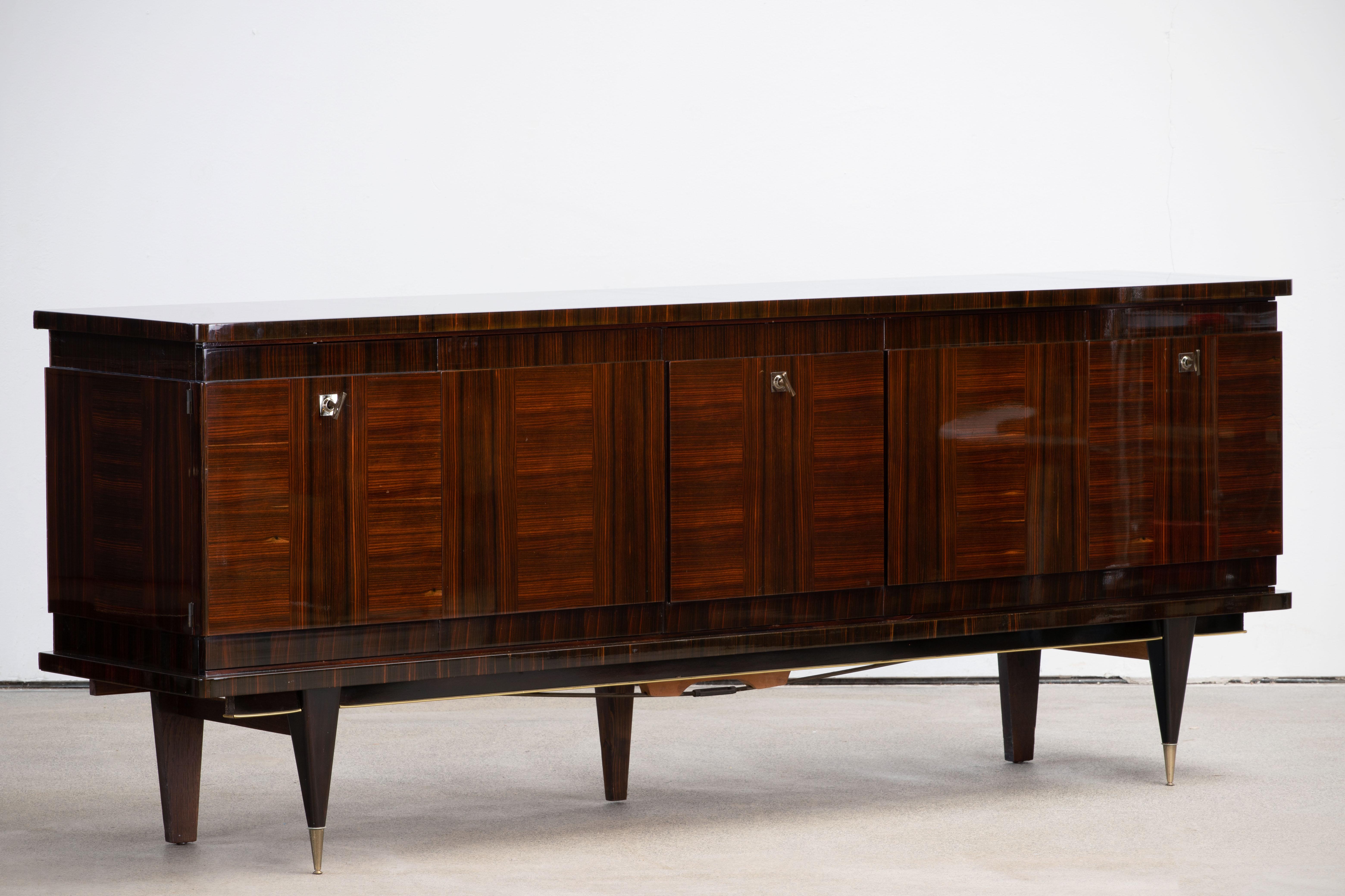 French Art Deco sideboard, credenza. The sideboard features stunning Macassar wood grain with a geometric pattern in the center. It offers ample storage, with shelve behind the doors. Both sides of the cabinet lock, and three keys are included. The
