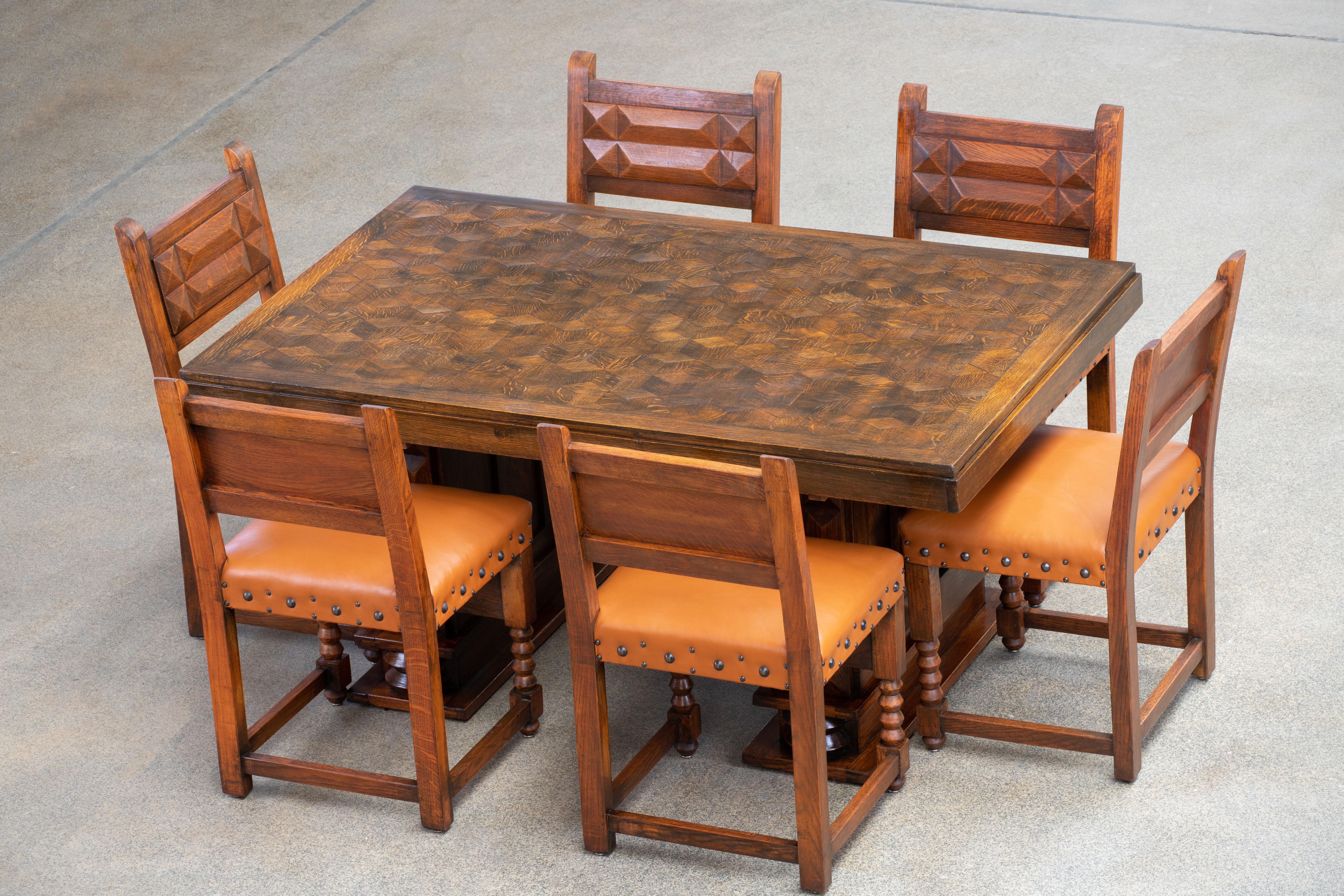 French Art Deco dining table. The table features stunning oak with a stunning patina. The top is encrusted with an octogonal marquetry. 
It rests on tall and Brutalist tapered legs.
The table is in excellent original condition, with minor wear