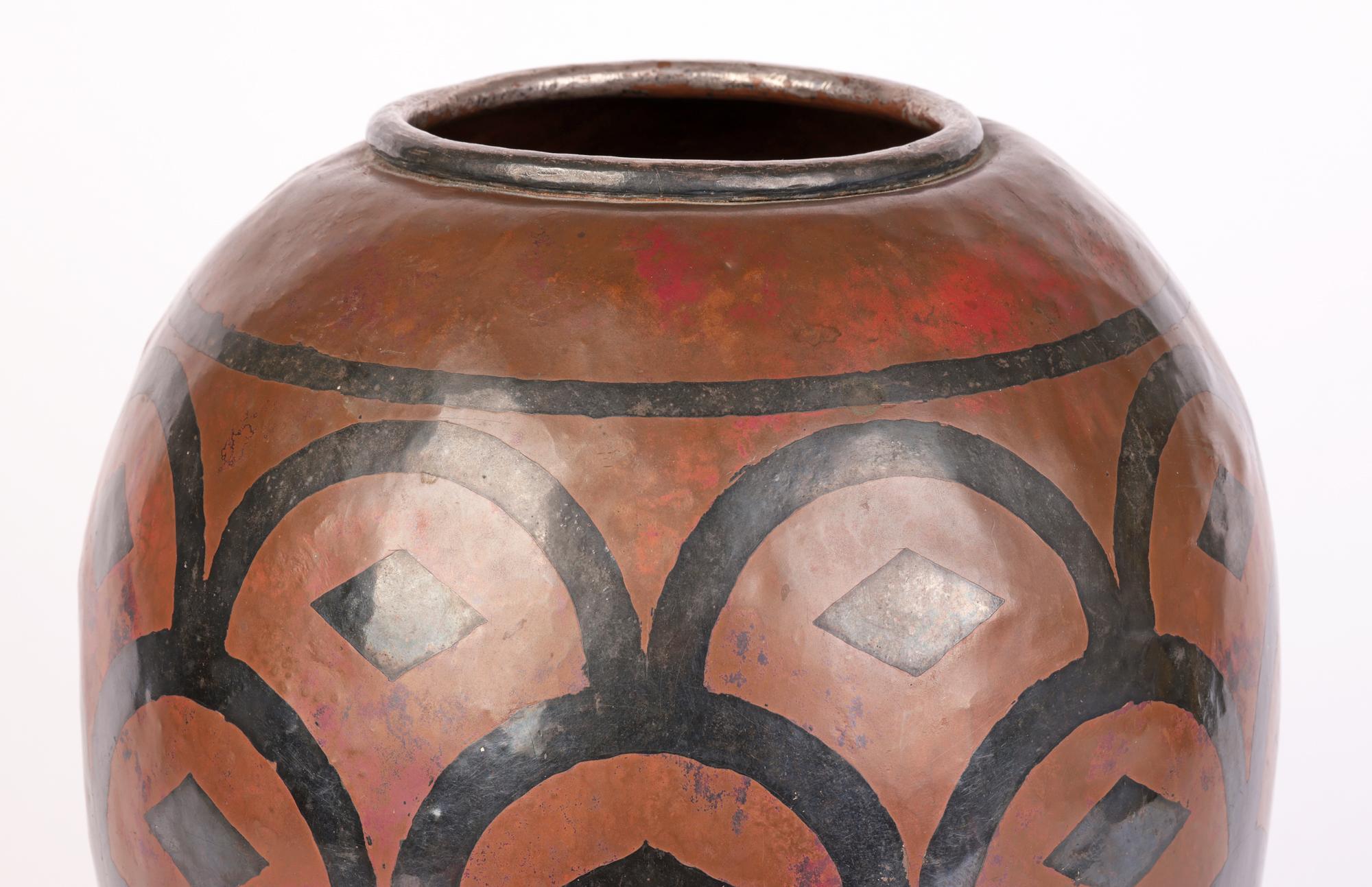 Un grand et élégant vase en cuivre Art Nouveau français décoré d'un motif de superposition d'argent signé Dubois et datant d'environ 1900. Le grand vase de forme bulbeuse repose sur une base ronde plate et étroite et est fabriqué à la main avec un