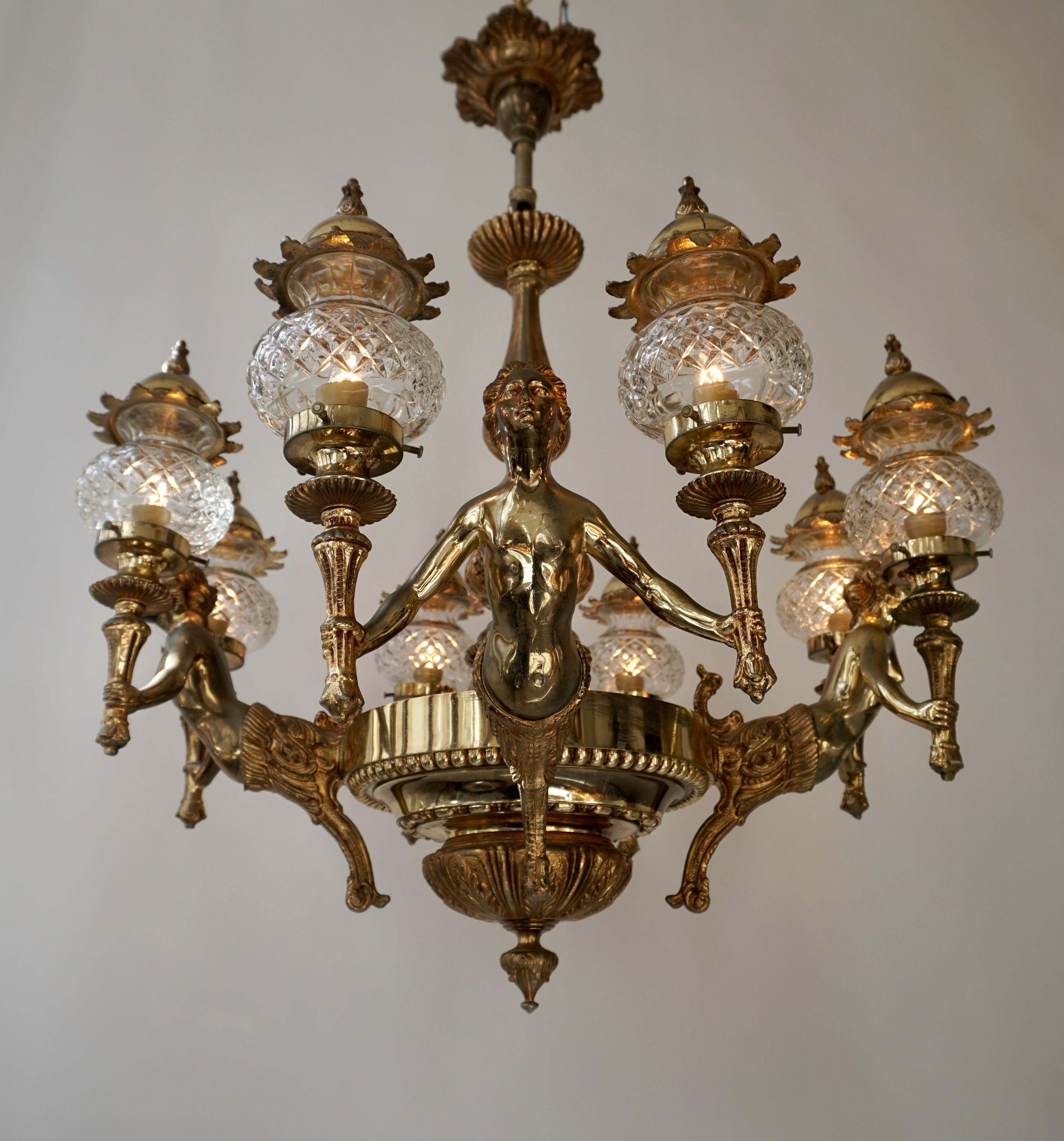 Large French bronze chandelier with angels holding double torches with crystal globes.
Italy, circa 1950.

Measures: Diameter 27 inch - 68 cm.
Height fixture 24 inch - 61 cm.
Total height including the chain and ceiling plate is 32 inch - 80