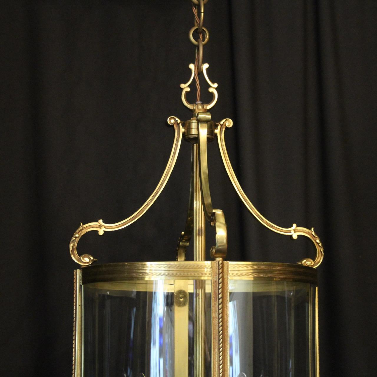 A French large gilded bronze four light convex antique lantern, the four scrolling light fittings surrounded by four sectional circular convex glass panels and held within a decorative leaf scrolling framework with barley twisted side sections, leaf