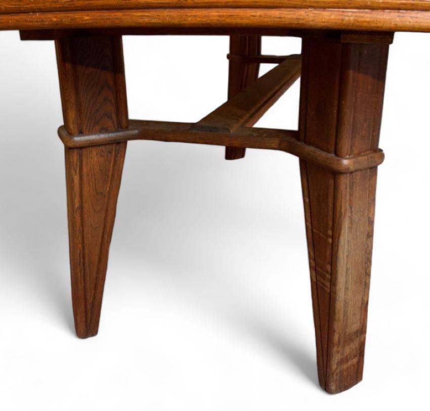 Grande table Art Déco en bois datant des années 1950.
La table est composée de 4 pieds courbes reliés par une entretoise en forme de H. Ses traits caractéristiques lui confèrent un esprit très design et moderne.
La table est extensible, en tirant